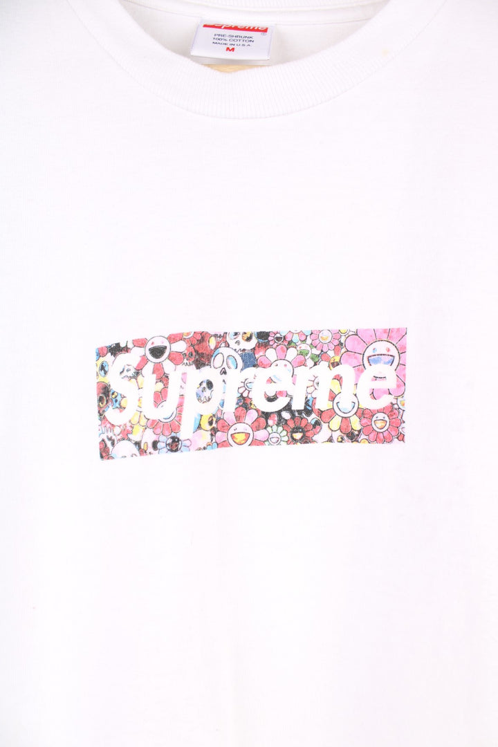 Supreme Murakami Relief Box Logo T-Shirt in a white colourway, has the supreme box logo with a floral emoji print going around, and also has 'Covid 19 Relief Fund 2020' printed on the back.