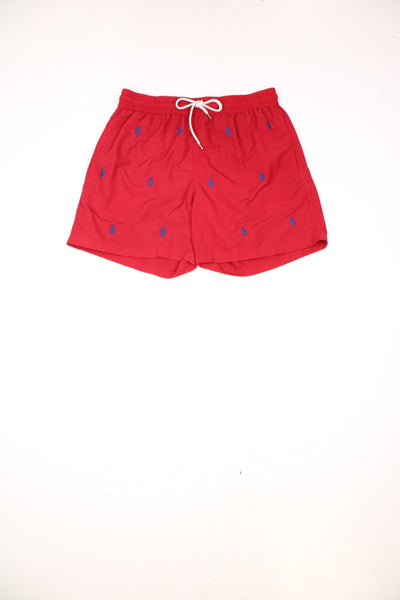 Ralph Lauren Swimming Short in a red and blue colourway with the logo embroidered all over, has a netted lining, adjustable waist and pockets.