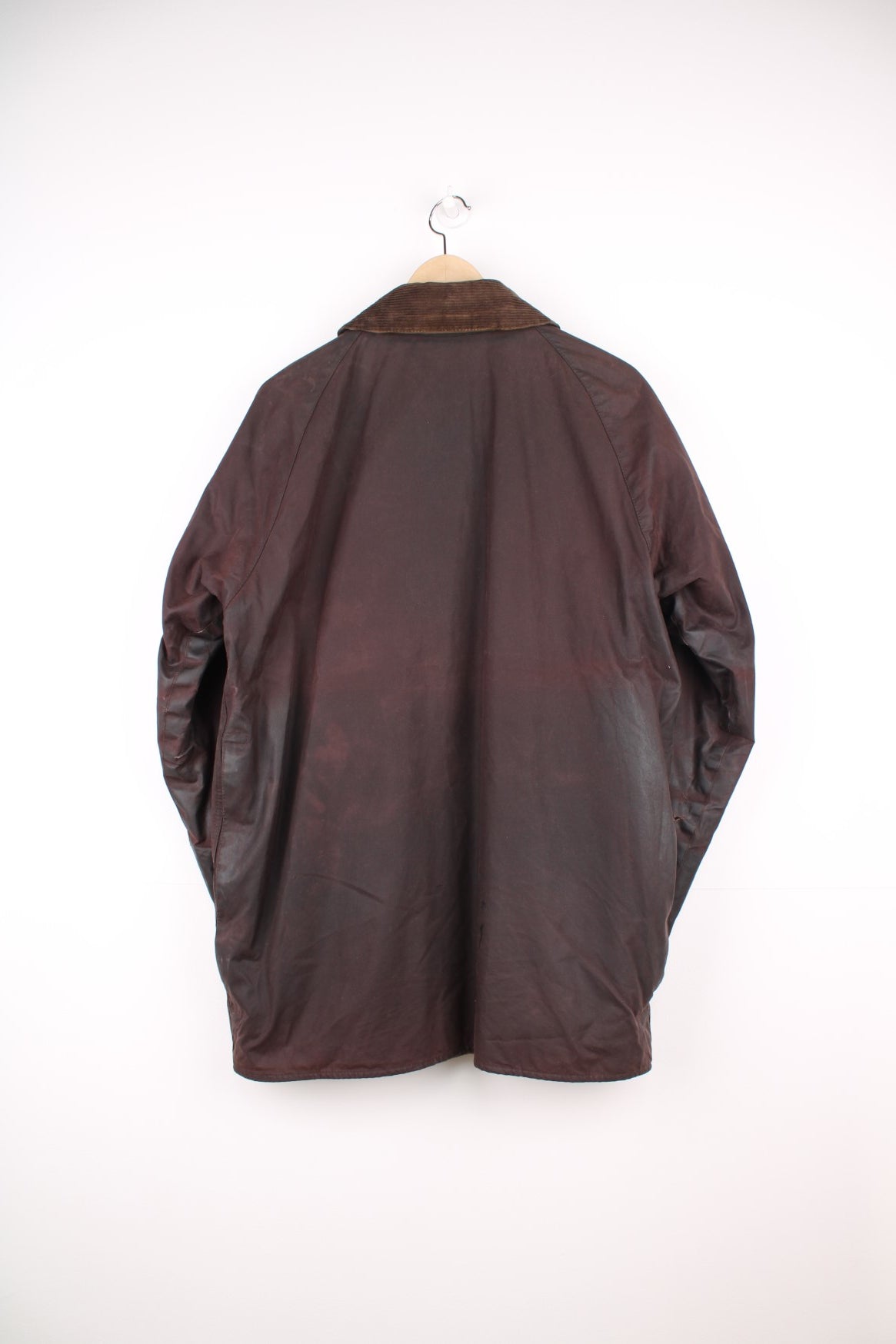 Vintage Barbour Beaufort Wax Jacket in a burgundy brown colourway with a corduroy collar that has a pin on it, zip up with multiple pockets, and has a tartan lining.