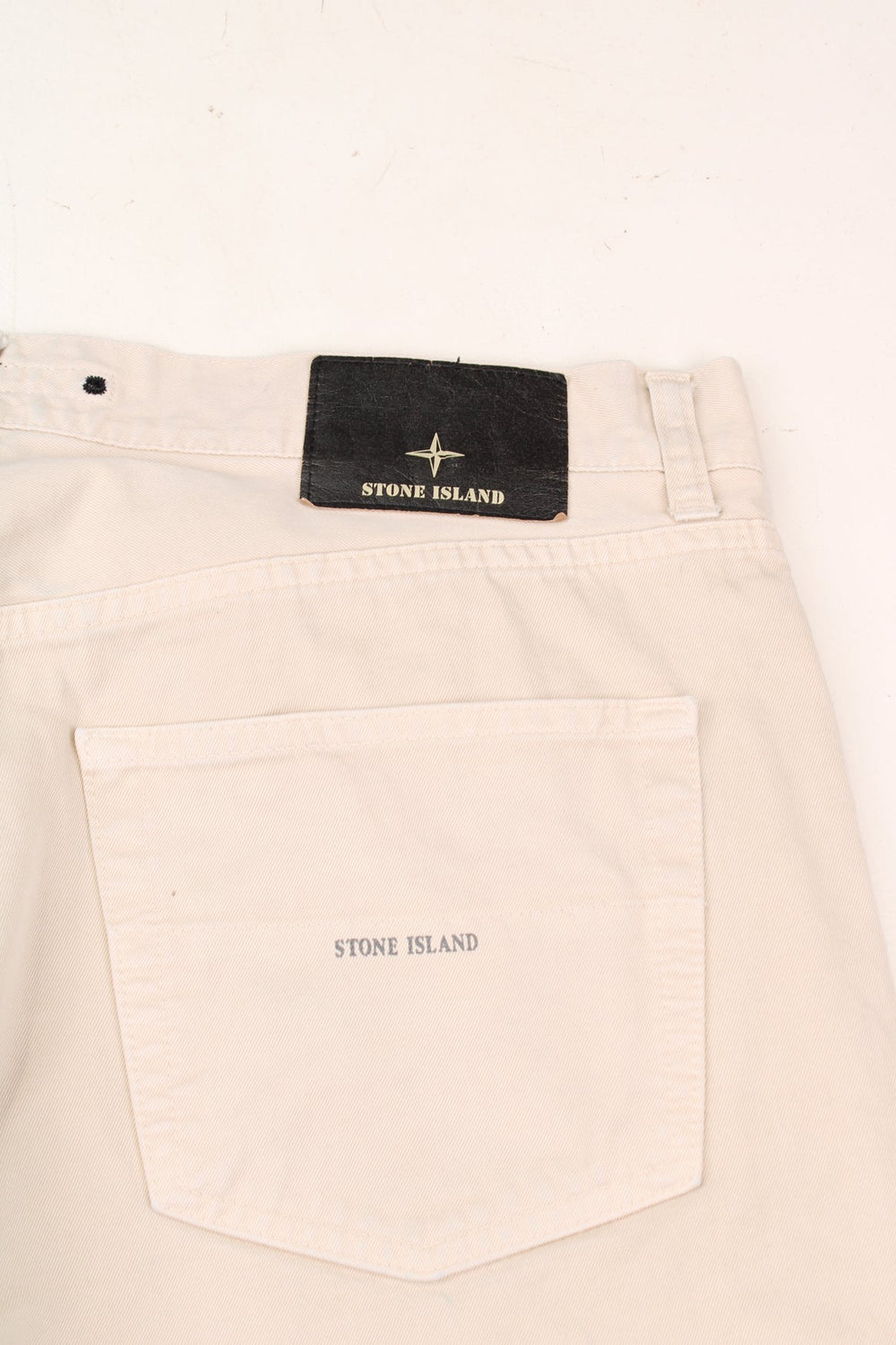 Stone Island made in Italy 100% cotton jeans/trousers in a cream colourway, features leather badge on the waistband and printed spell-out logo on the back pocket