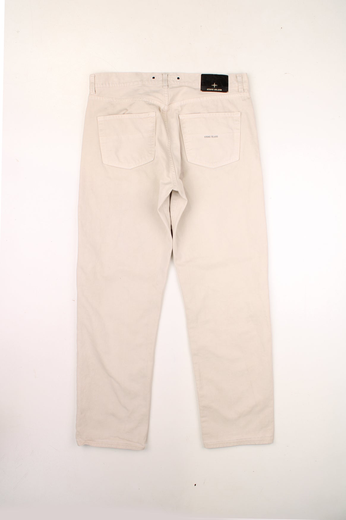 Stone Island made in Italy 100% cotton jeans/trousers in a cream colourway, features leather badge on the waistband and printed spell-out logo on the back pocket