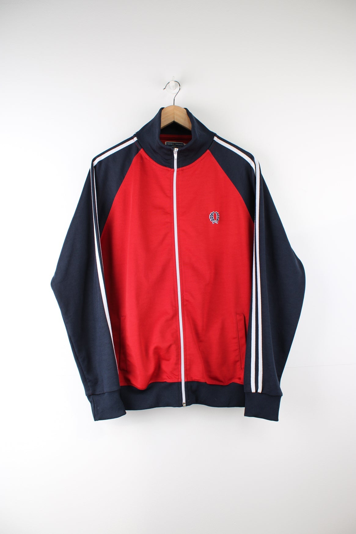 Fred Perry red and navy zip through tracksuit jacket, features signature embroidered logo on the chest and white stripes down the sleeves