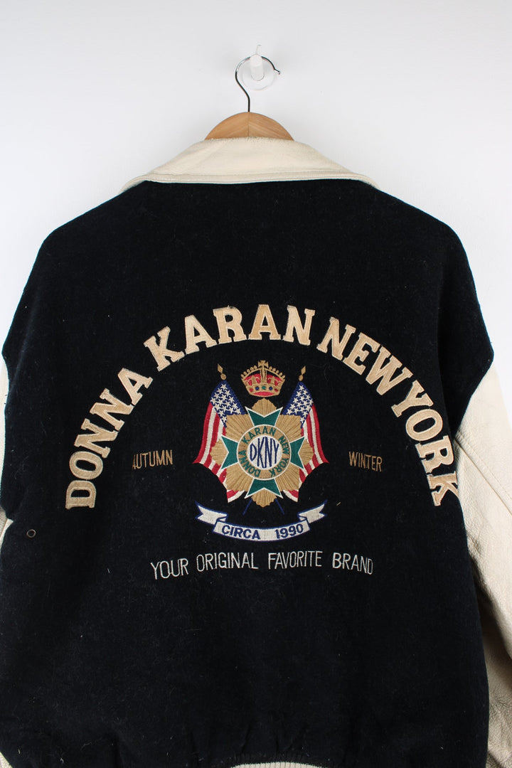 Vintage 90's DKNY black and white varsity jacket with wool body and leather sleeves, features embroidered badges and large spell-out motif on the back 