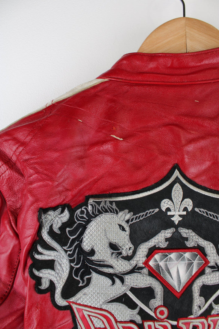 Vintage red leather Avirex zip through motorcycle jacket with white detailing and embroidered badges on the front/back.