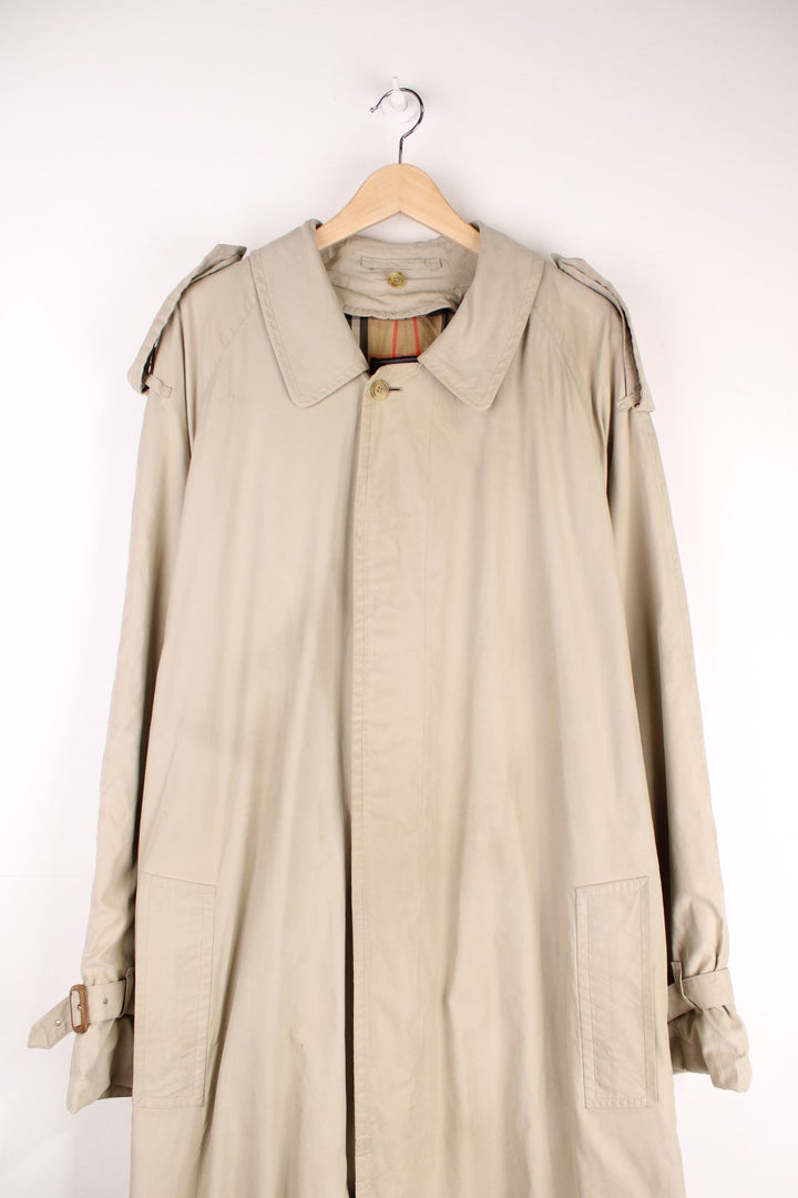 Vintage Burberry Trench Coat in a tan colourway, nova check lining, buttons up and has side pockets and a belt. 