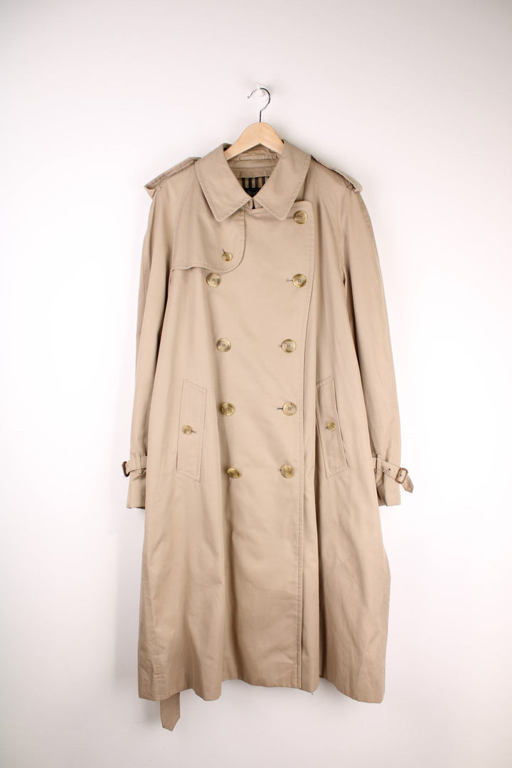 Vintage Burberry Trench Coat in a tan colourway, nova check lining, buttons up and has side pockets and a belt. 