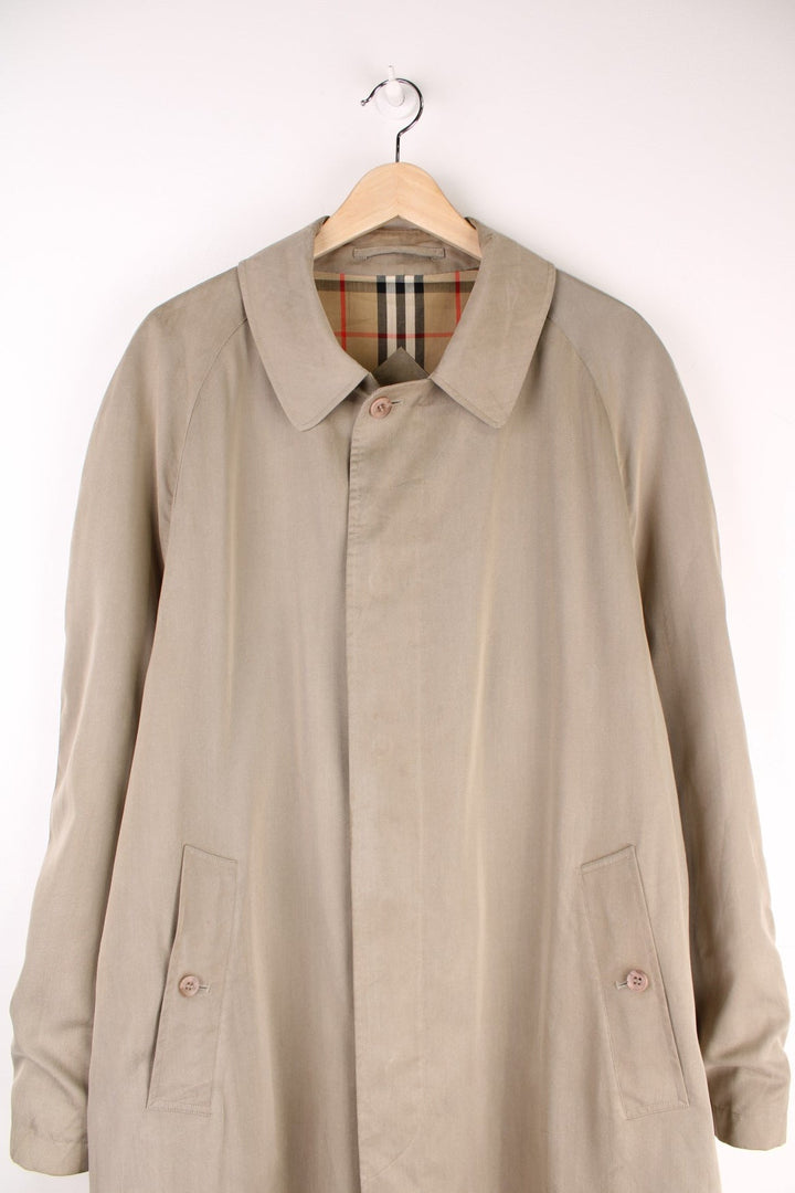 Vintage Burberry Trench Coat in a tan colourway, nova check lining, buttons up and has side pockets and a belt. 