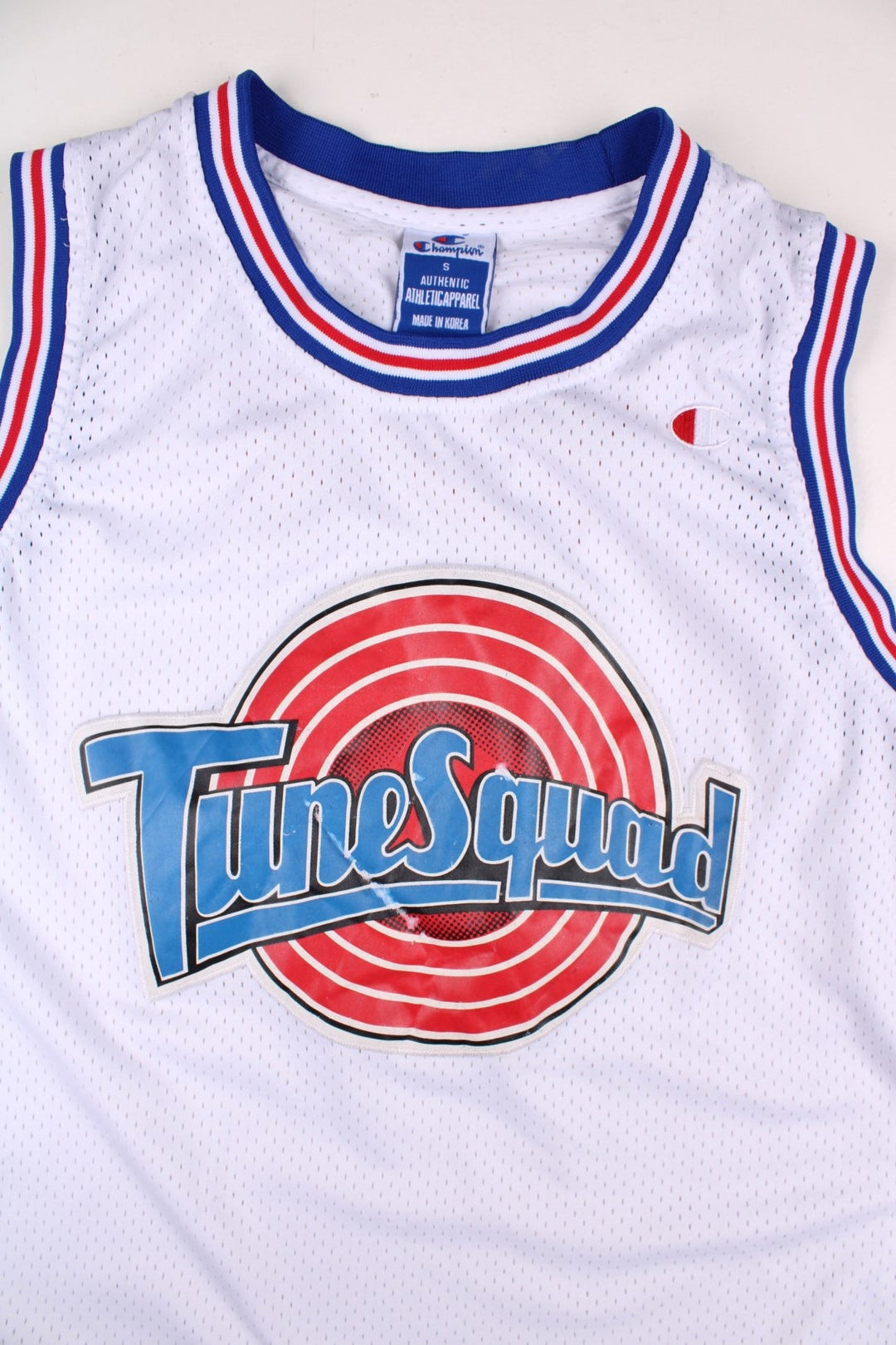 Looney Tune Space Jam Tunes Squad Champion Basketball Jersey in the white, red and blue kit colourway, features embroidered logos and badge on the front, and Buggs number 1 on the back.