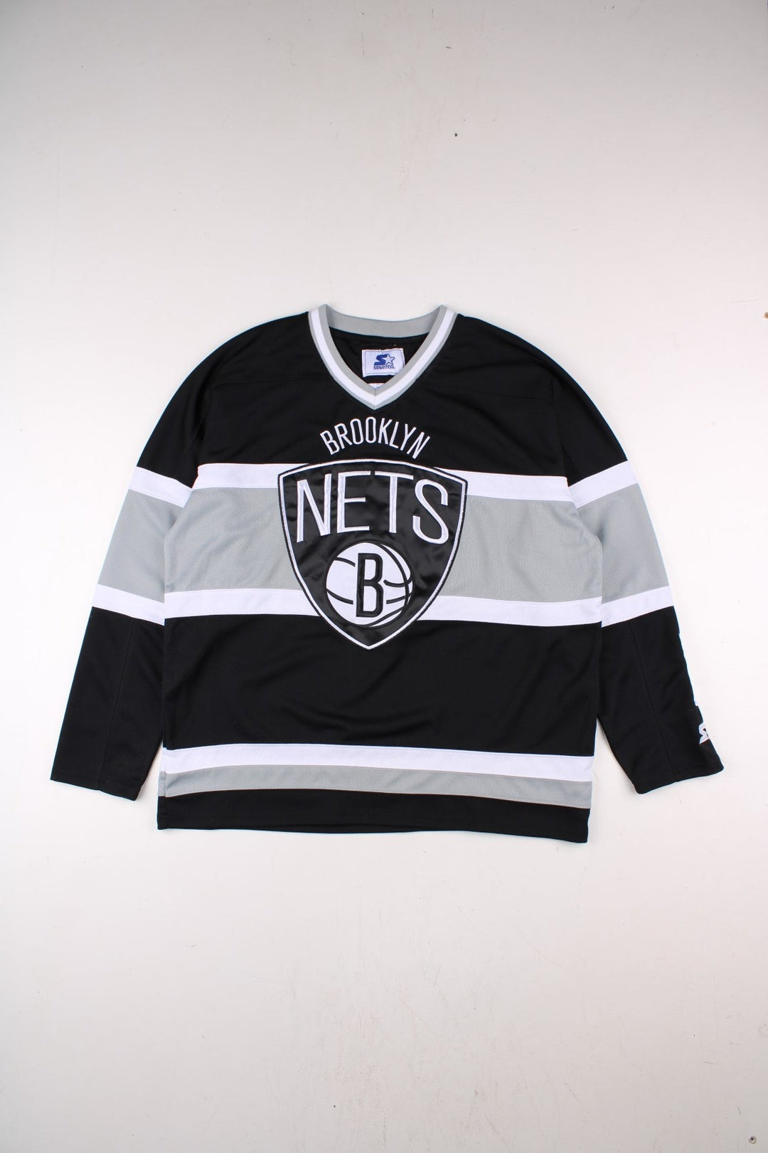 Y2K Brooklyn Nets NBA Starter Basketball Jersey in the black, white and grey kit colourway, features embroidered logos and badge on the front, and the Starter spell out logo going down the left arm.