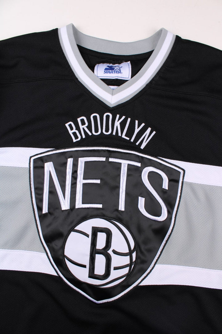 Y2K Brooklyn Nets NBA Starter Basketball Jersey in the black, white and grey kit colourway, features embroidered logos and badge on the front, and the Starter spell out logo going down the left arm.