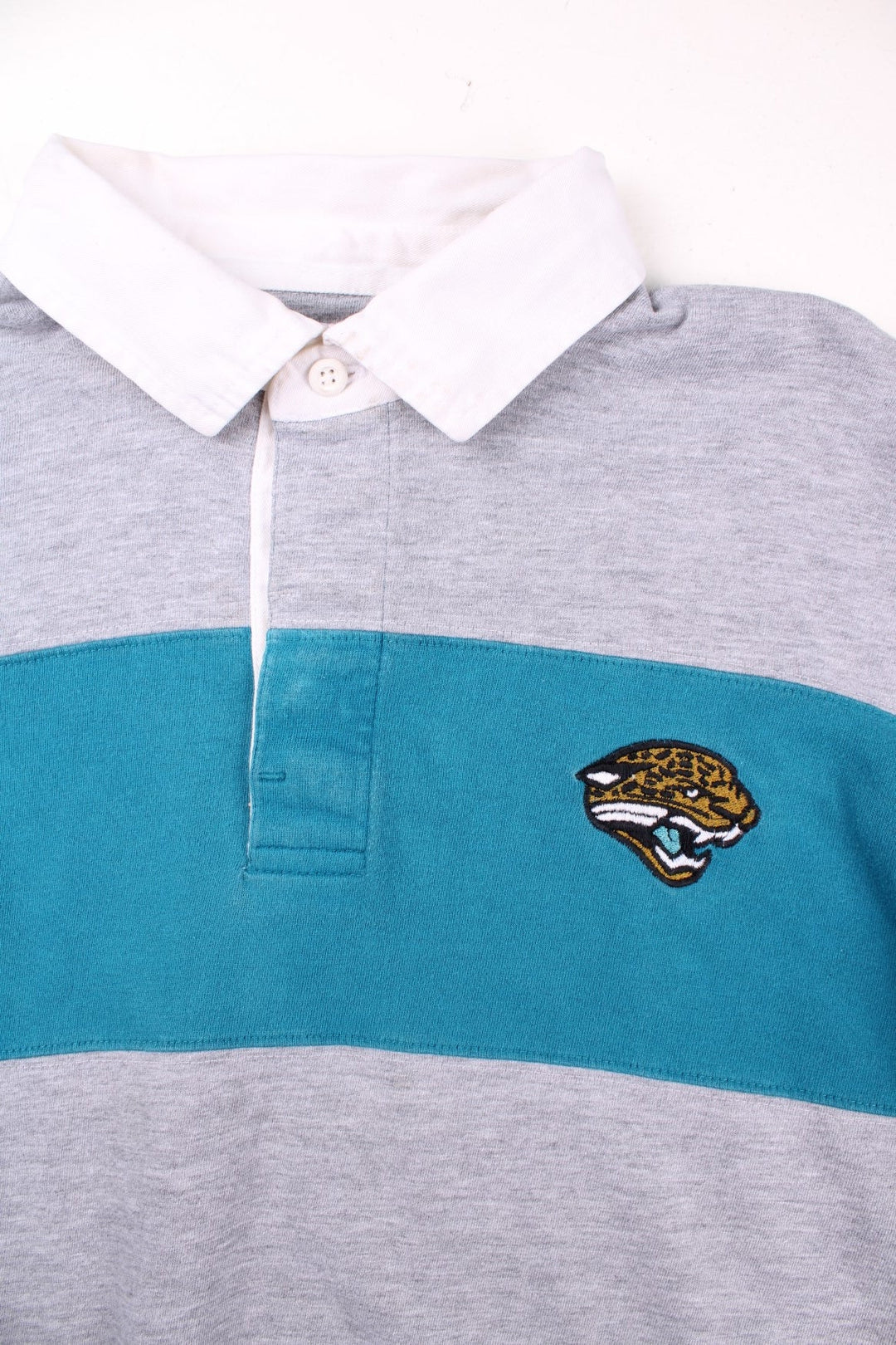 Vintage Jacksonville Jaguars NFL Polo Shirt in a grey and blue colourway, button up collar, and has the team logo embroidered on the front.