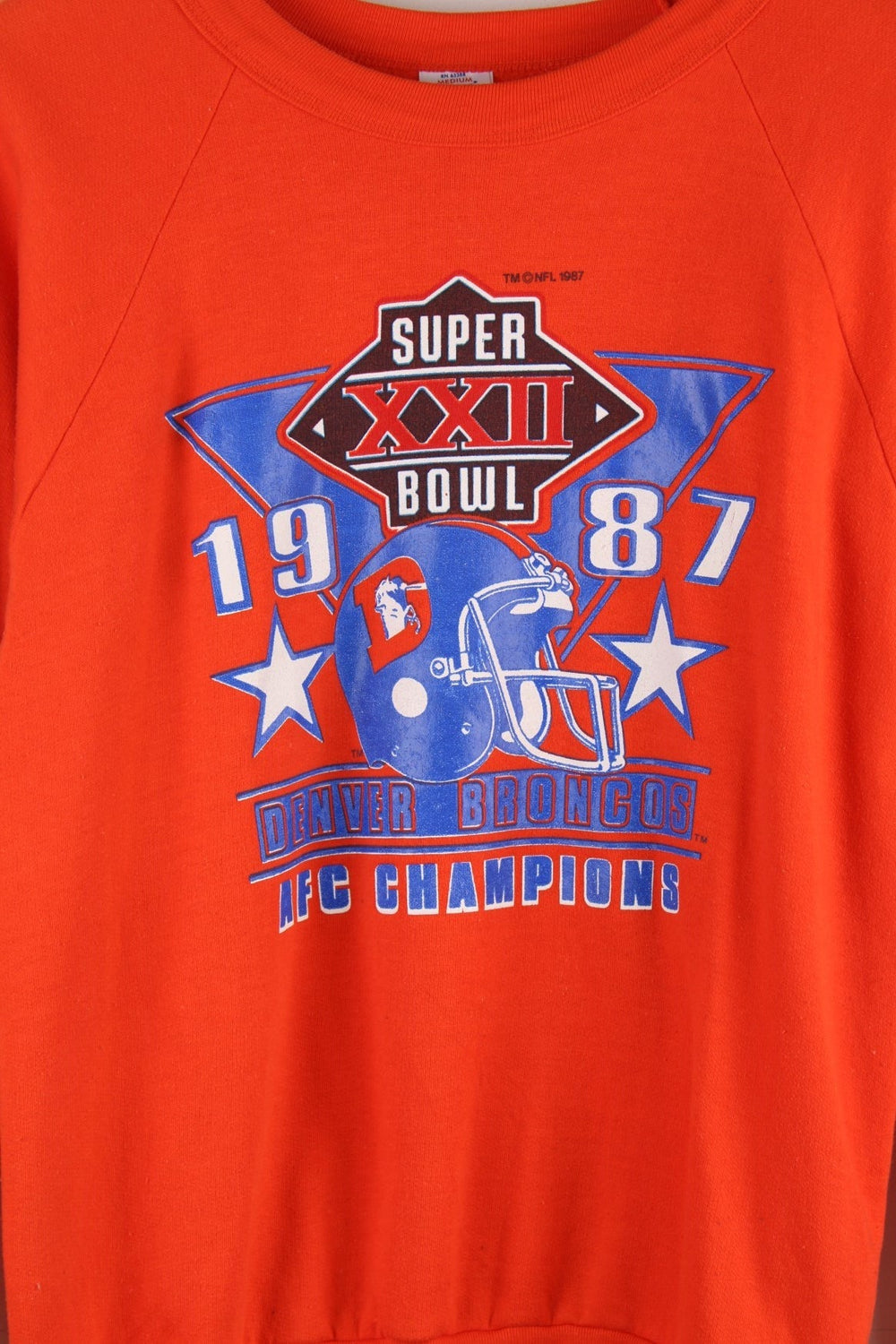 Vintage Denver Broncos 1987 Super Bowl sweatshirt in orange with blue and white logo graphic on the front.