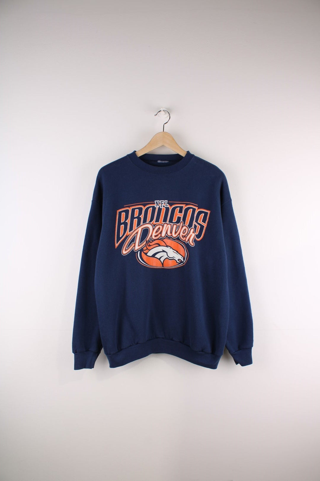 Vintage Denver Broncos NFL sweatshirt in navy blue with an orange and white spellout and horse logo.