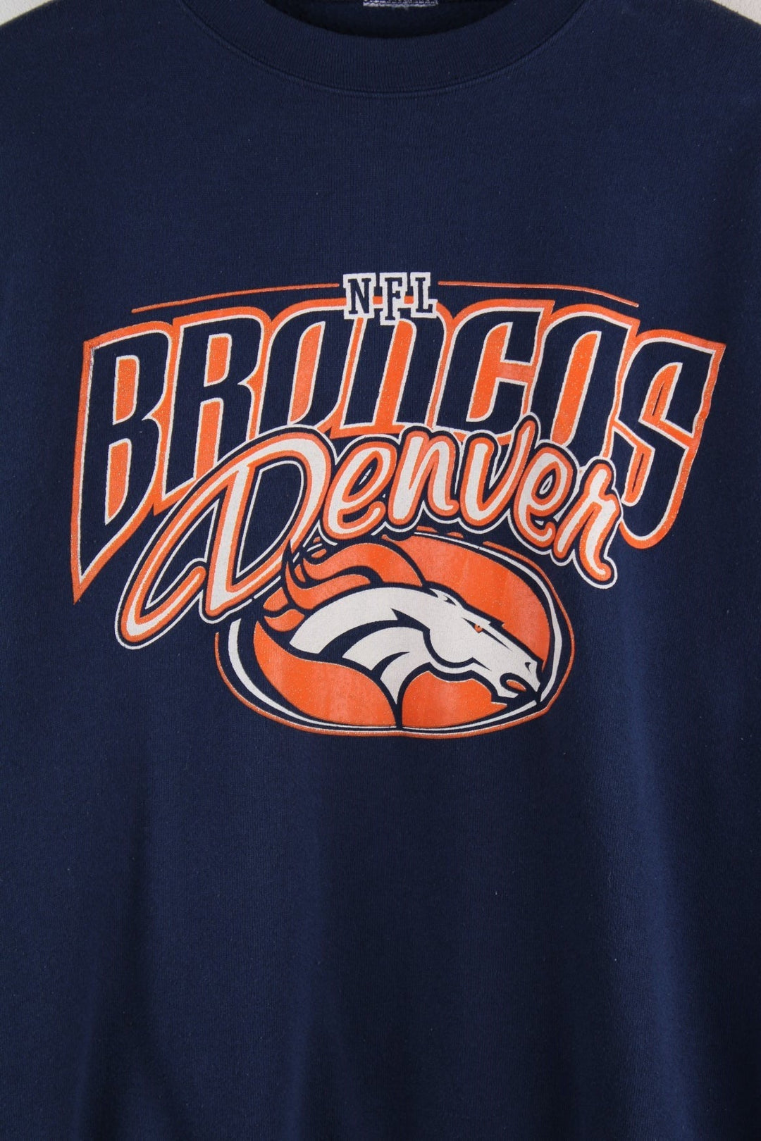 Vintage Denver Broncos NFL sweatshirt in navy blue with an orange and white spellout and horse logo.