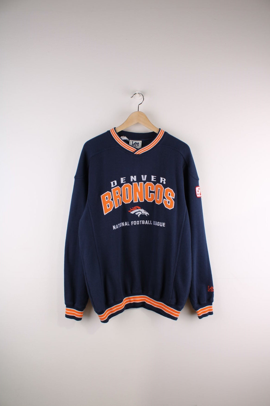 Lee Sport Denver Broncos NFL sweatshirt in navy blue with an orange and white spellout and small embroidered horse logo on the front.