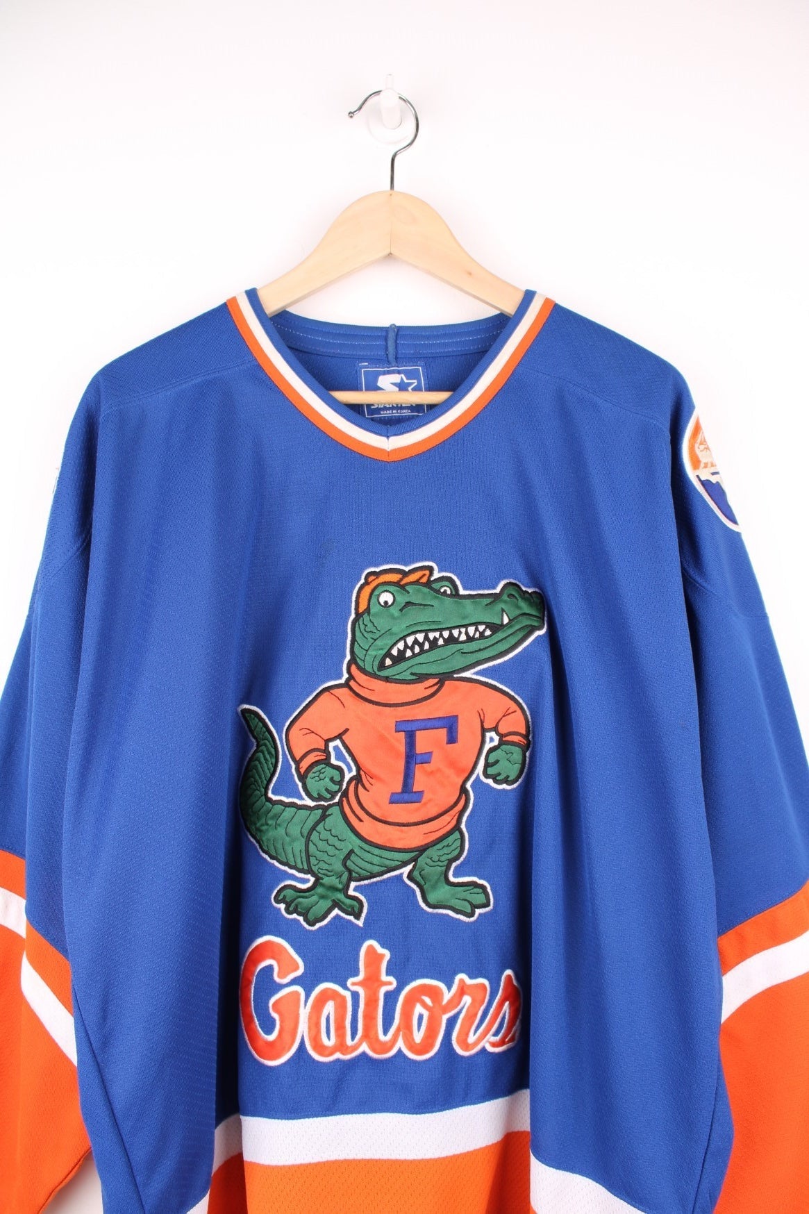 University Of Florida Gators Hockey Jersey in a blue, white and orange colourway, and has the logos embroidered on the front and back. 