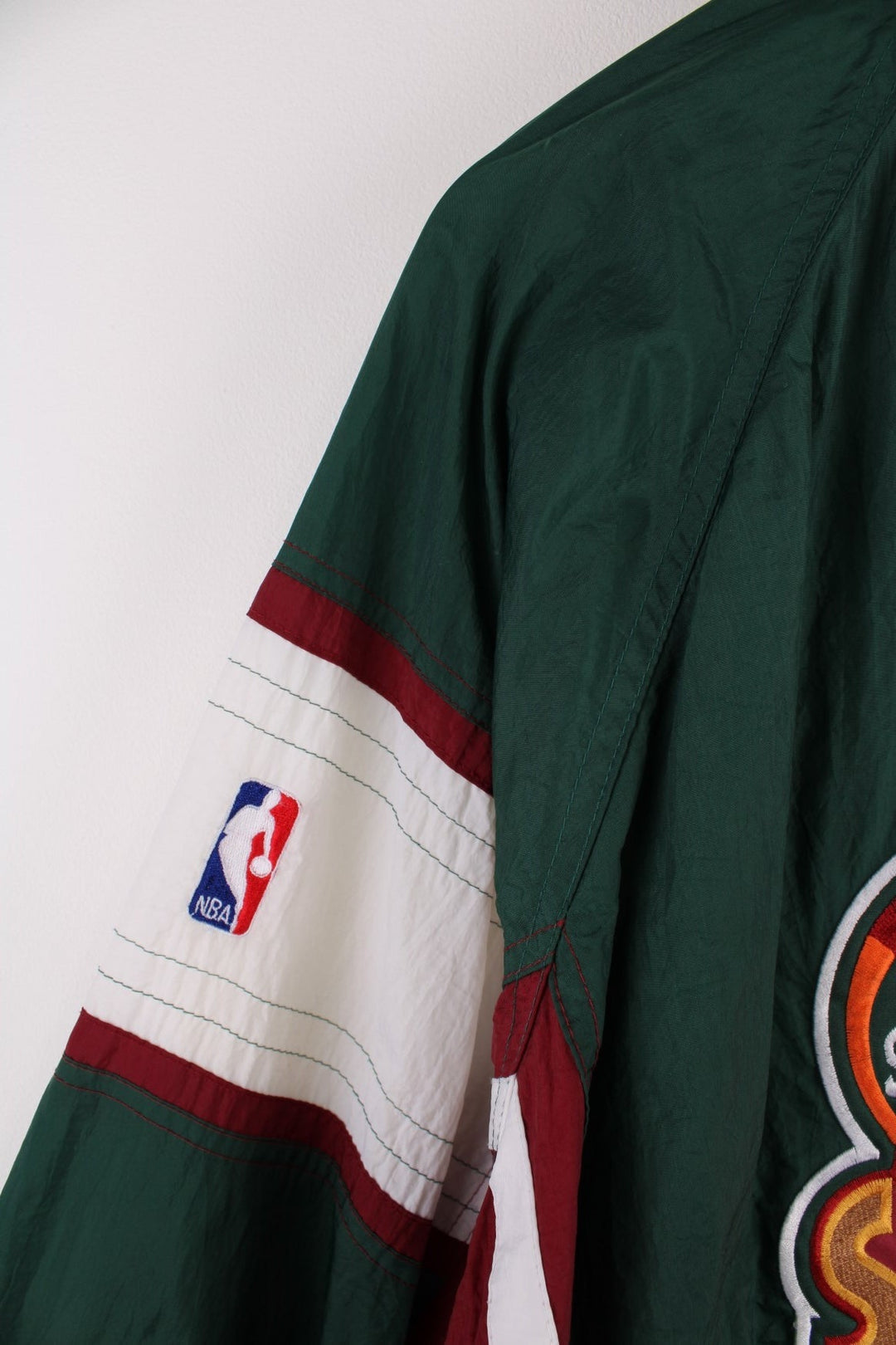 Seattle SuperSonics NLF jacket in  with burgundy and white panels, two pockets, an embroidered team logo on the back and NBA logo on the sleeve.