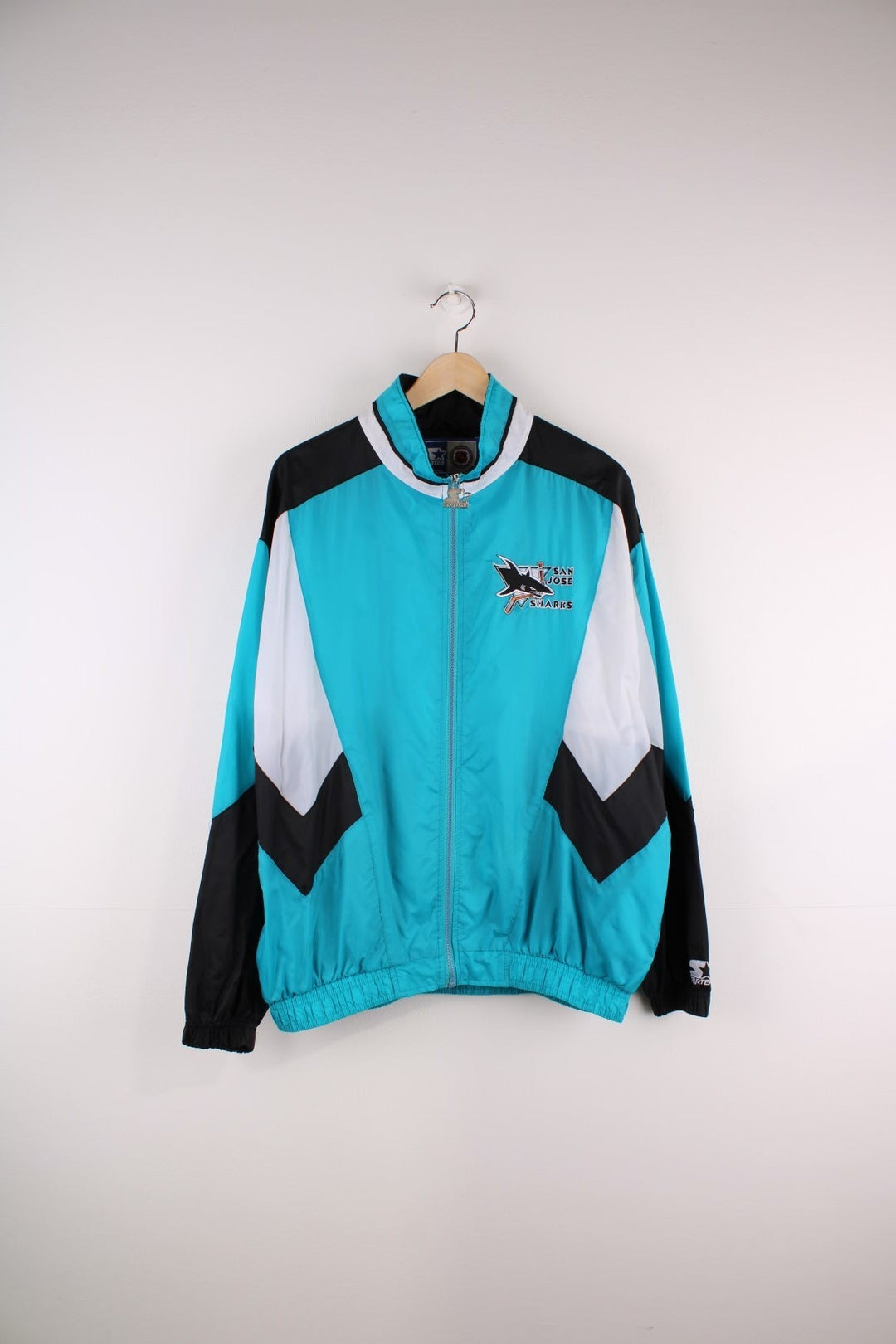 San Jose Sharks Starter Jacket in blue with black and white panels and the team logo embroidered on the chest and back.