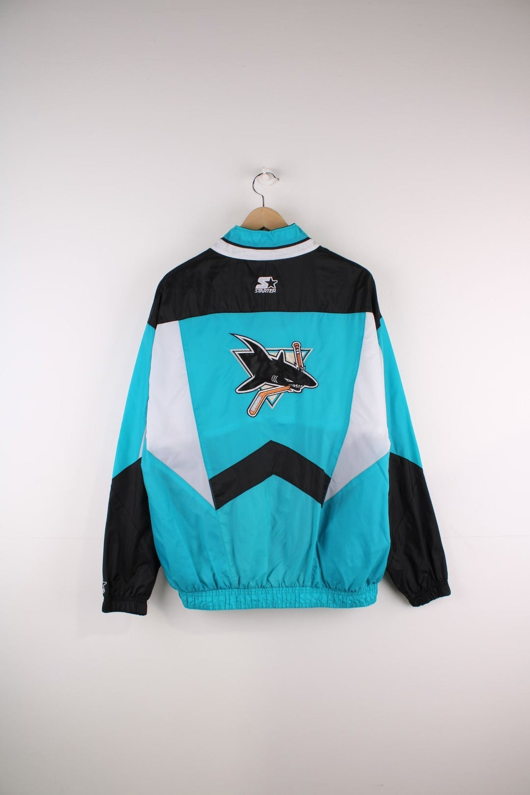 San Jose Sharks Starter Jacket in blue with black and white panels and the team logo embroidered on the chest and back.