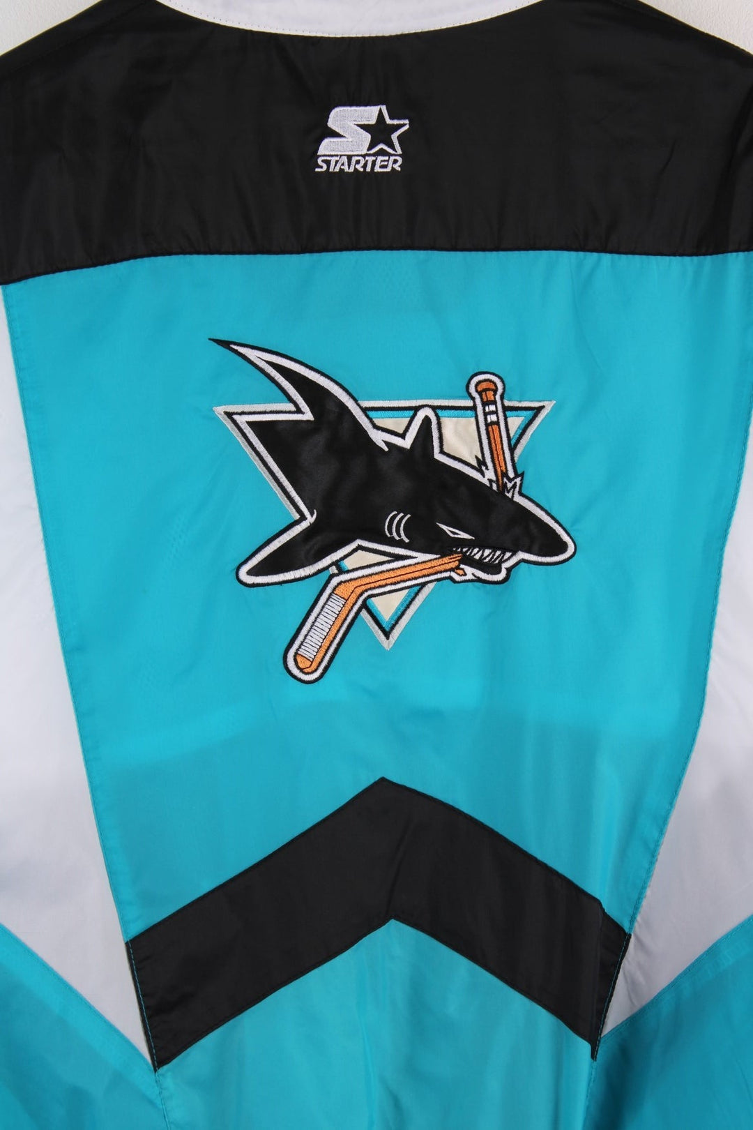 San Jose Sharks Starter Jacket in blue with black and white panels and the team logo embroidered on the chest and back.