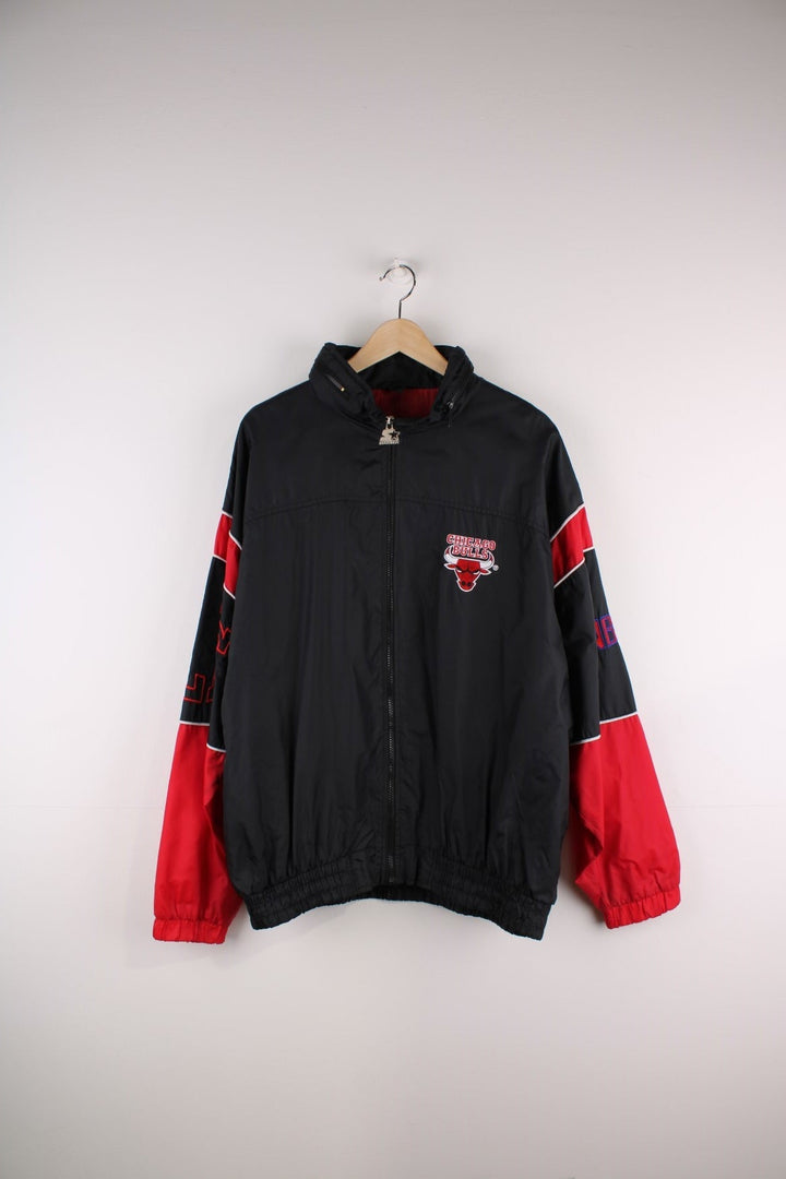 Chicago Bulls Starter Jacket in black with red panels and white piping, the Bull logo on the chest, and 'NBA', 'Bulls' and 'Starter' on the sleeves and back.