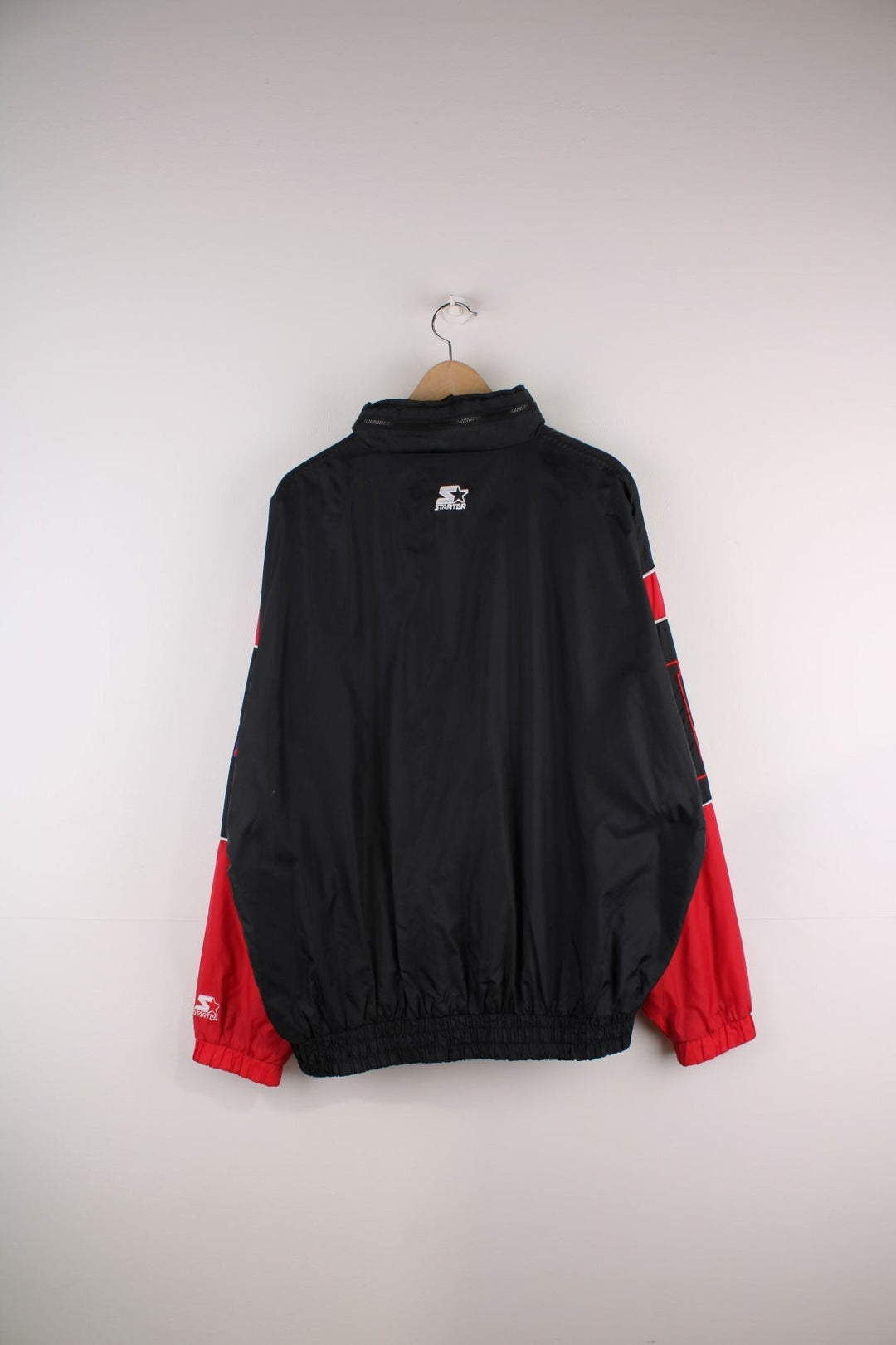 Chicago Bulls Starter Jacket in black with red panels and white piping, the Bull logo on the chest, and 'NBA', 'Bulls' and 'Starter' on the sleeves and back.