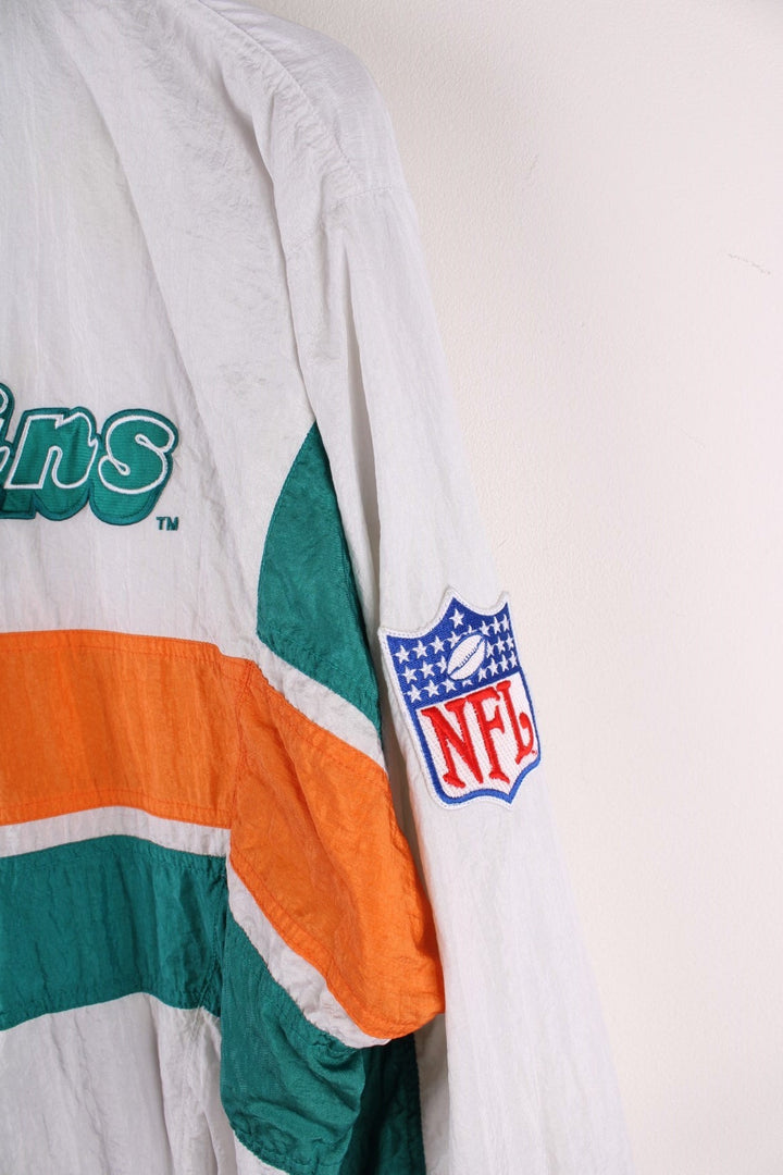 Miami Dolphins  Jacket in  with turquoise and orange stripes, the dolphin logo on the chest and script on the back, and Apex and NFL logos on each sleeve.