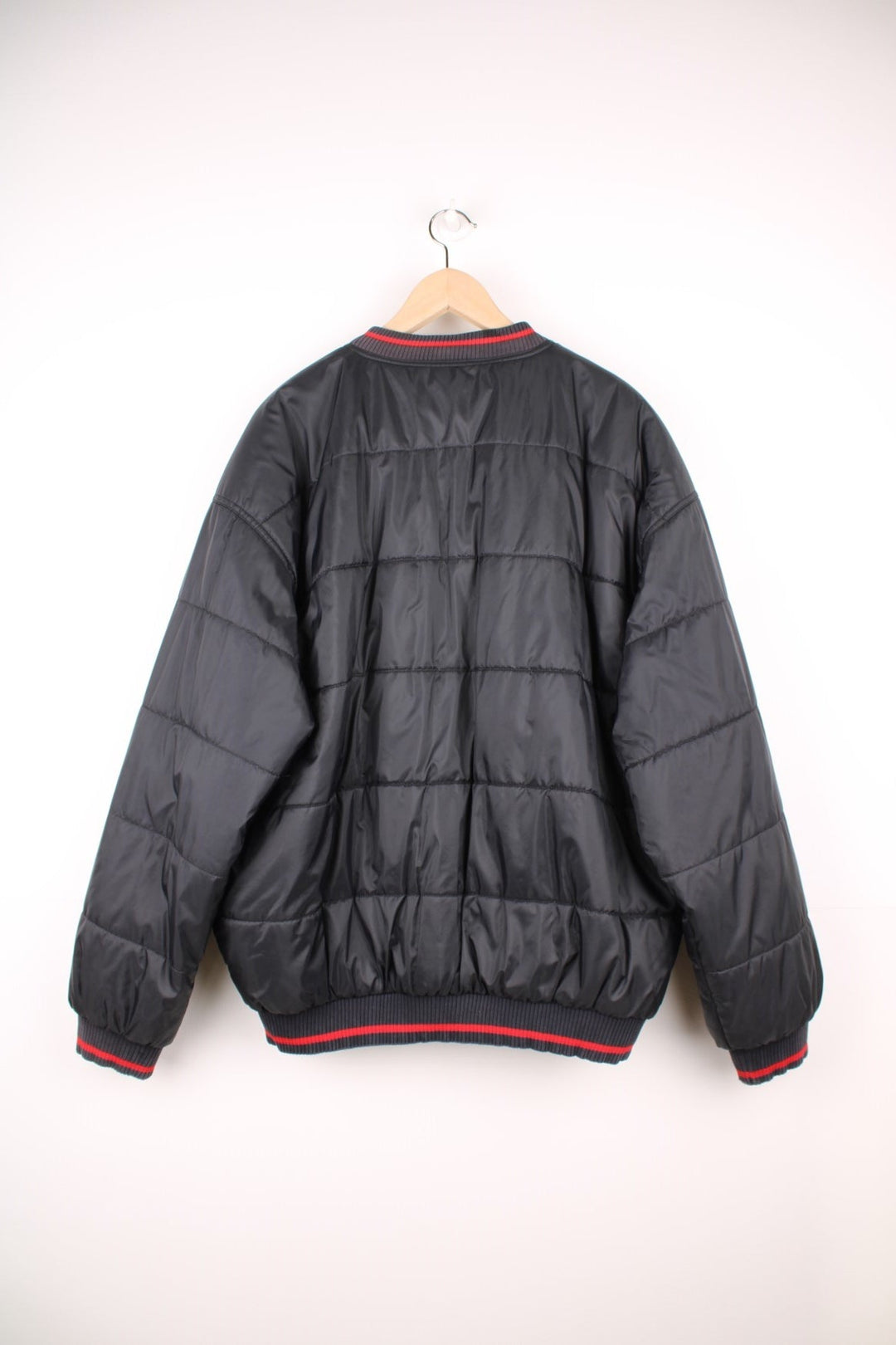 NBA Chicago Bulls Puffer Coat in a black and red colourway, zip up with side pockets, insulated lining, and has the logo embroidered on the front. 