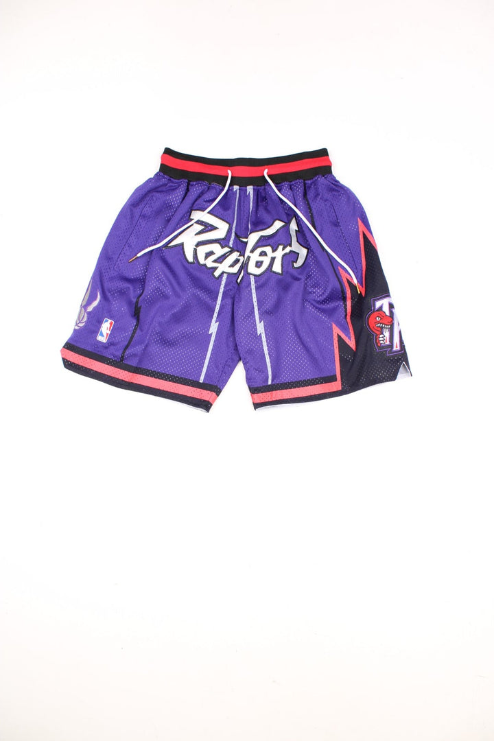 Toronto Raptors Basketball Shorts in a purple, silver, black and red colourway, has a adjustable waist with drawstrings, multiple pockets, and the logos and spell out embroidered on the front.