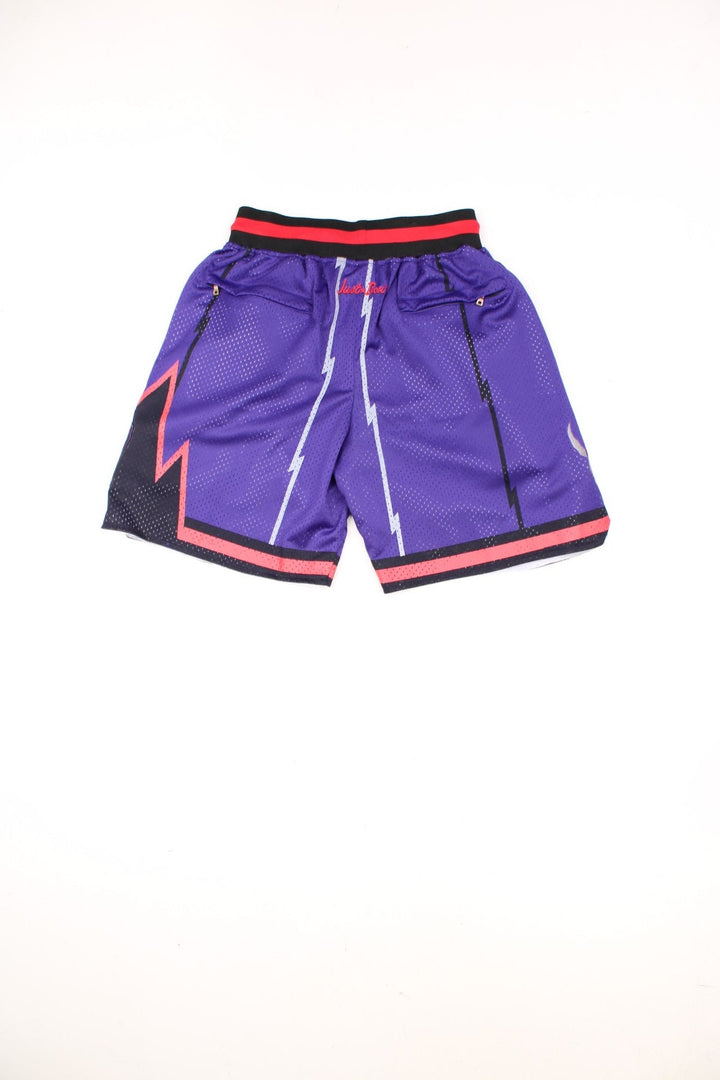 Toronto Raptors Basketball Shorts in a purple, silver, black and red colourway, has a adjustable waist with drawstrings, multiple pockets, and the logos and spell out embroidered on the front.