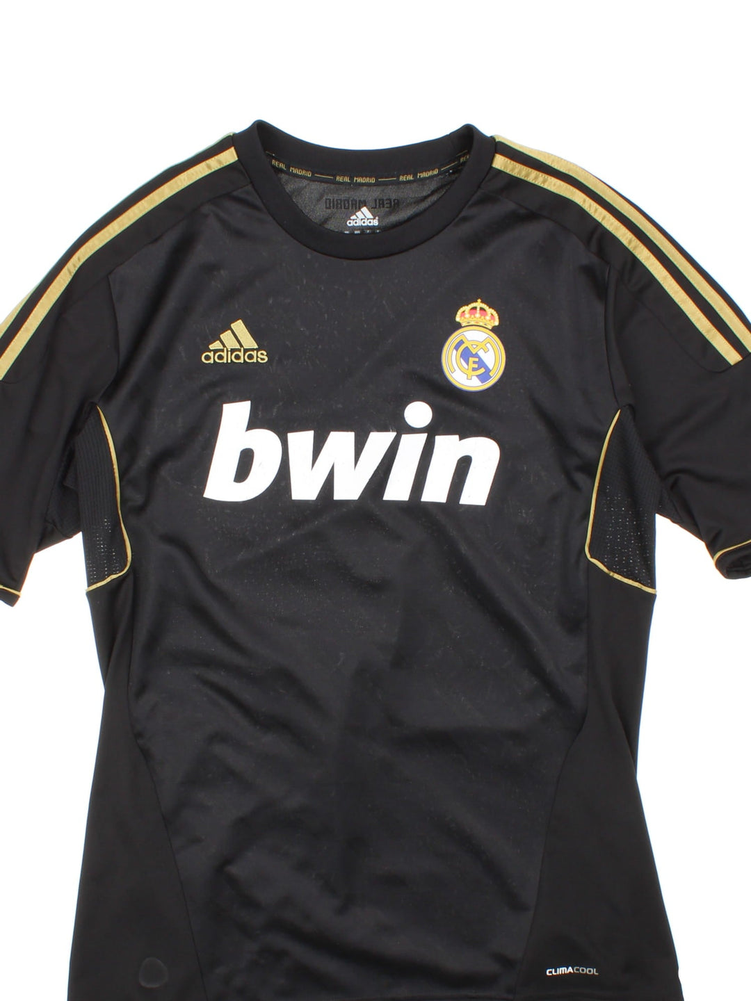 Real Madrid 2011/12 Adidas football shirt in the away kit black with gold three stripe detailing, printed and embroidered logos, and a badge on the front.