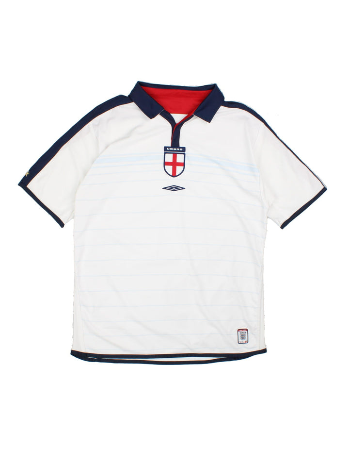 England 2003/05 Umbro home kit reversible football shirt in white with blue stripes and navy blue collar and piping on one side, red on the other. 2 snap closure at the neck, and a logo and badge on the front on both sides.