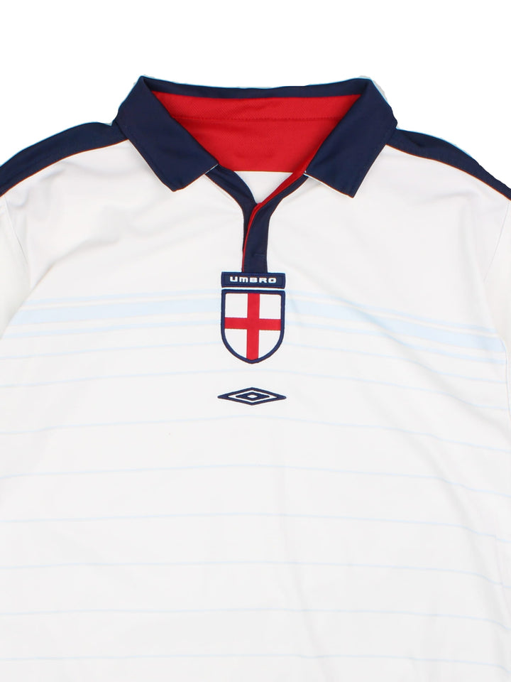 England 2003/05 Umbro home kit reversible football shirt in white with blue stripes and navy blue collar and piping on one side, red on the other. 2 snap closure at the neck, and a logo and badge on the front on both sides.