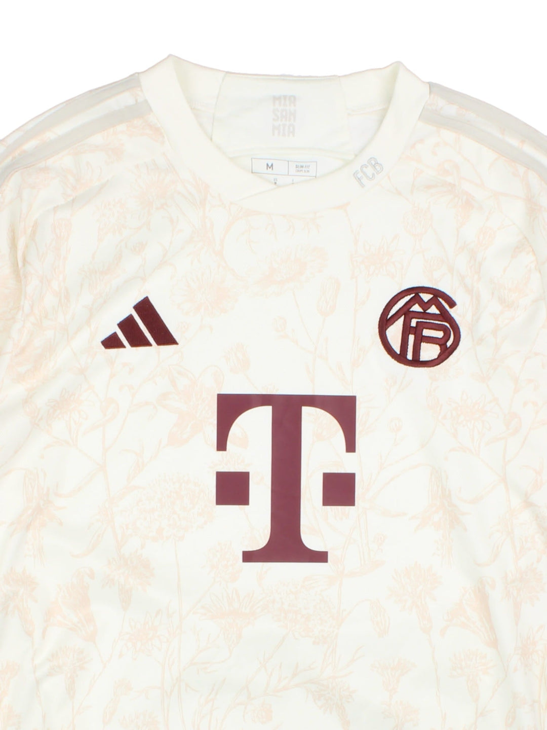 FC Bayern 2023/24 Adidas third kit football shirt in tan with subtle floral print, three stripe detailing in white, and logos and a badge on the front.