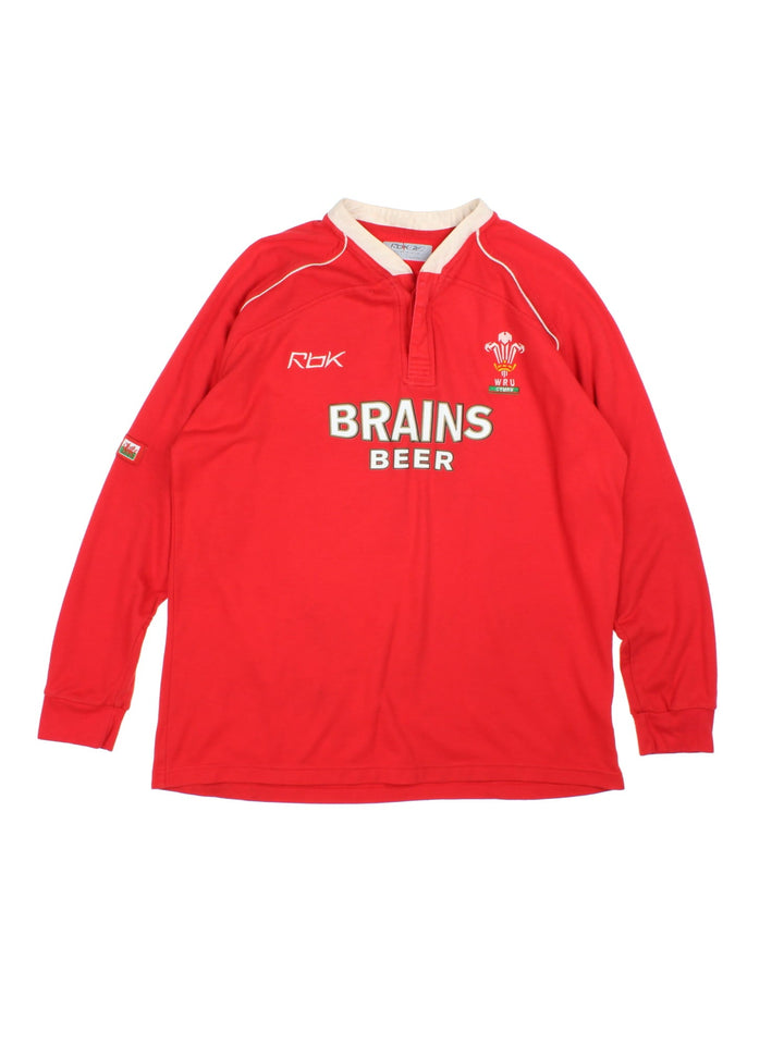 Reebok 2007/08 Wales Rugby Union shirt in red with 2 buttons at the collar, white piping, and printed and embroidered team and sponsor logos on the front.