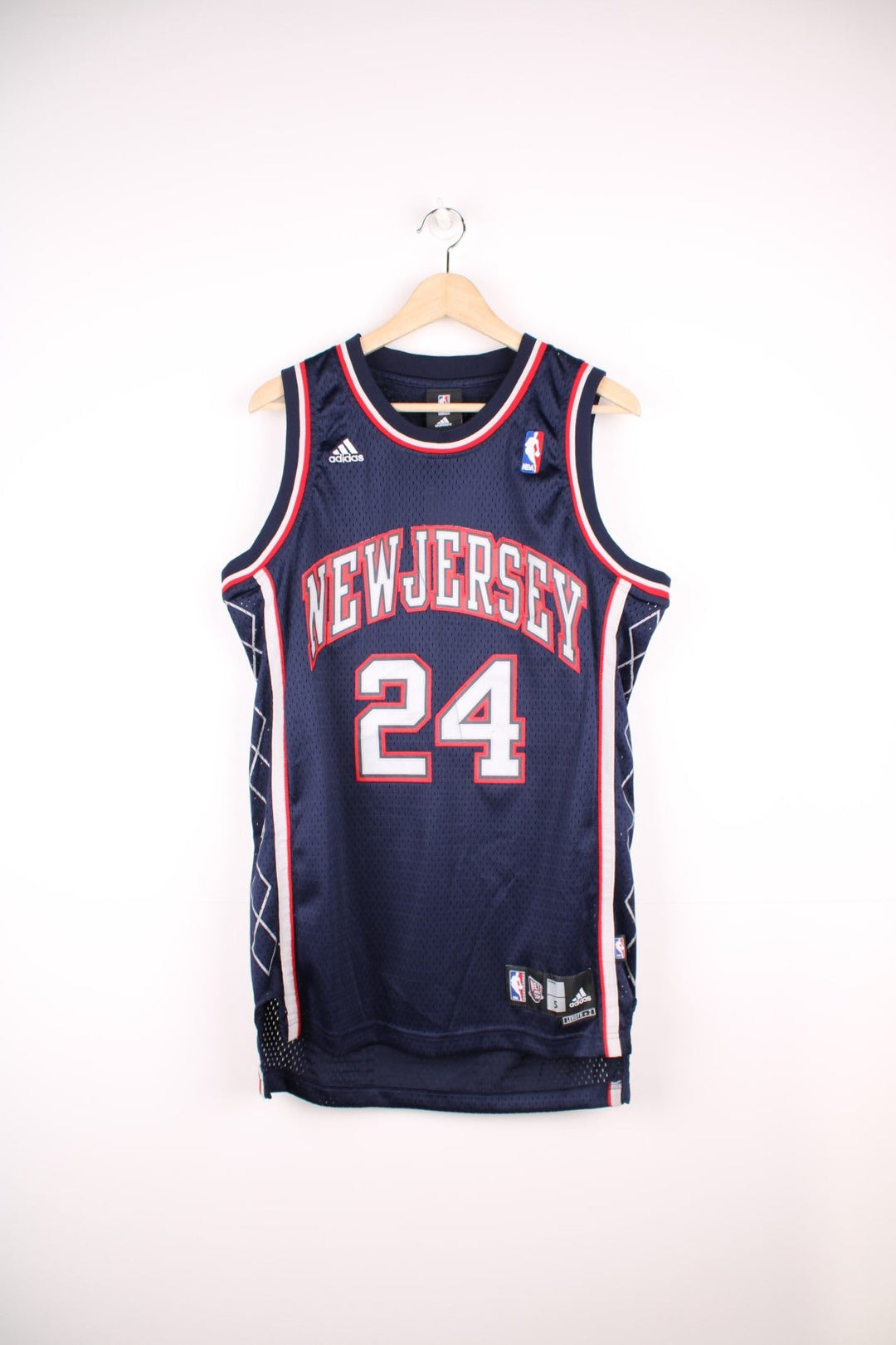 Vintage New Jersey Nets NBA Jersey in a blue, red and grey colourway, Richard Jefferson number 24 embroiderd on the back, team have since moved and renamed to become the brooklyn nets, and is deadstock with the tags still on.