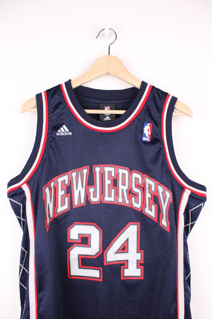 Vintage New Jersey Nets NBA Jersey in a blue, red and grey colourway, Richard Jefferson number 24 embroiderd on the back, team have since moved and renamed to become the brooklyn nets, and is deadstock with the tags still on.