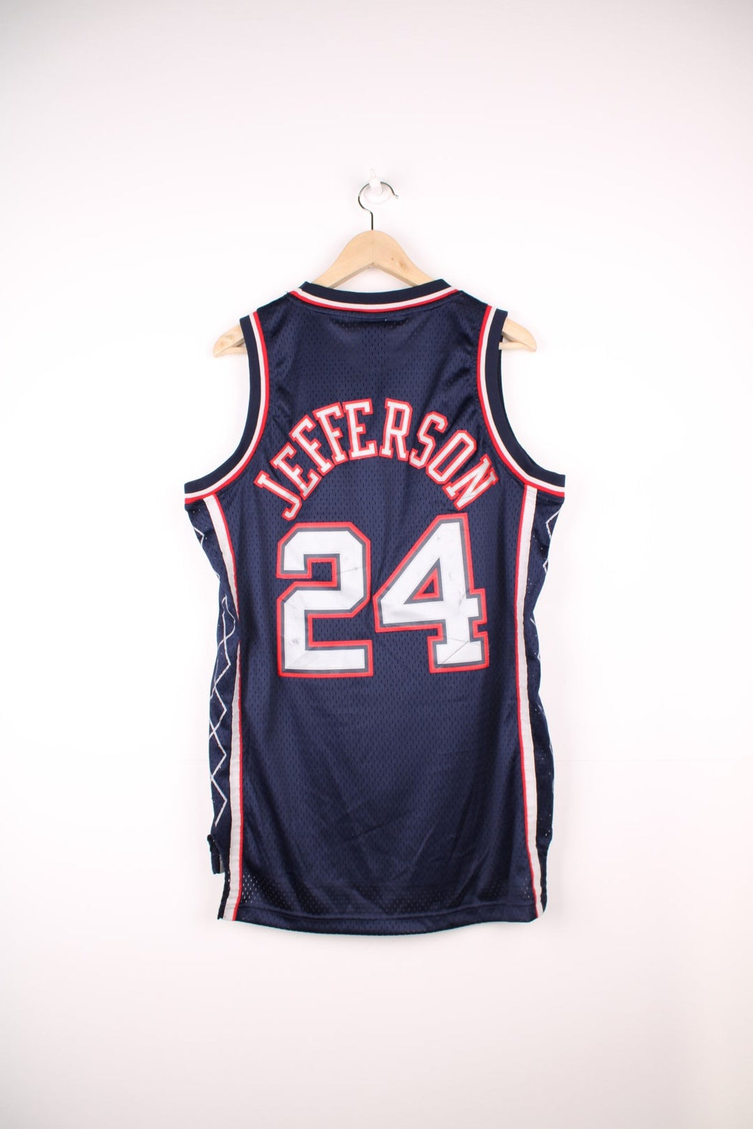 Vintage New Jersey Nets NBA Jersey in a blue, red and grey colourway, Richard Jefferson number 24 embroiderd on the back, team have since moved and renamed to become the brooklyn nets, and is deadstock with the tags still on.