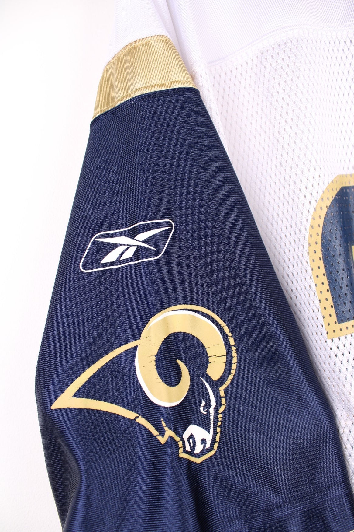 St. Louis Rams NFL Jersey in a white, blue and gold colourway, Marshall Faulk number 28 printed on the back, and has the logos on the front and sleeves. 