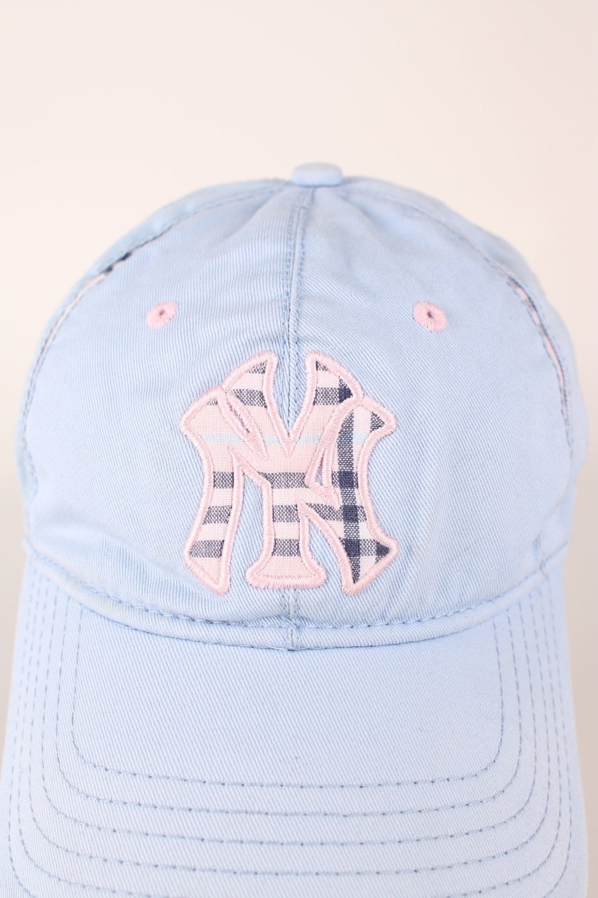 Vintage New York Yankees baseball cap in a blue and pink colourway with signature embroidered logo, check detailing and adjustable strap on the back.  