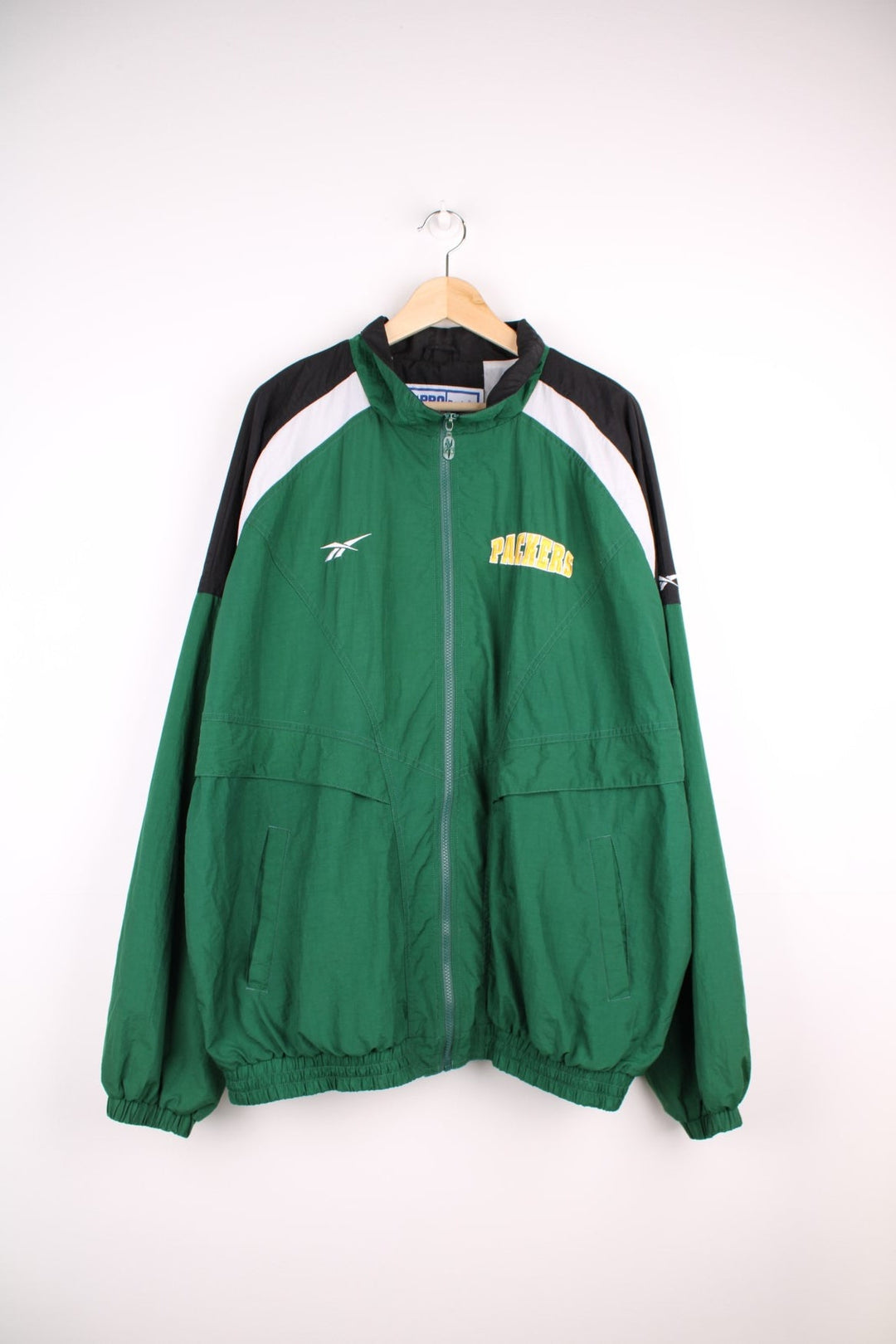 NFL Packers and Reebok pro sport jacket in a green colourway with white and black shoulder panels. Zip closure with team logos on the front and back.