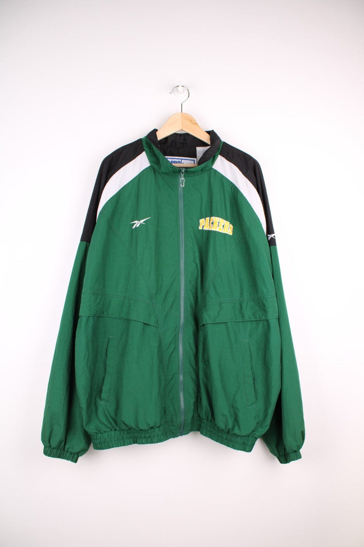 NFL Packers and Reebok pro sport jacket in a green colourway with white and black shoulder panels. Zip closure with team logos on the front and back.