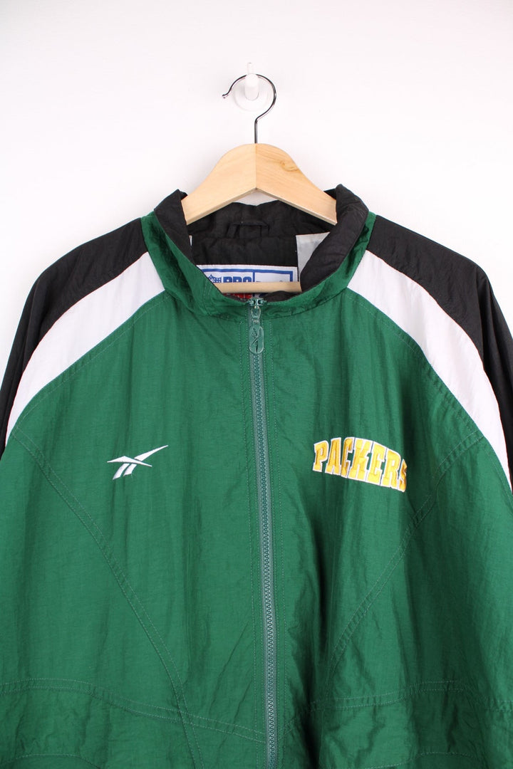 NFL Packers and Reebok pro sport jacket in a green colourway with white and black shoulder panels. Zip closure with team logos on the front and back.