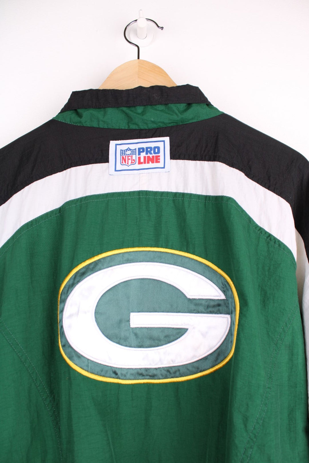 NFL Packers and Reebok pro sport jacket in a green colourway with white and black shoulder panels. Zip closure with team logos on the front and back.