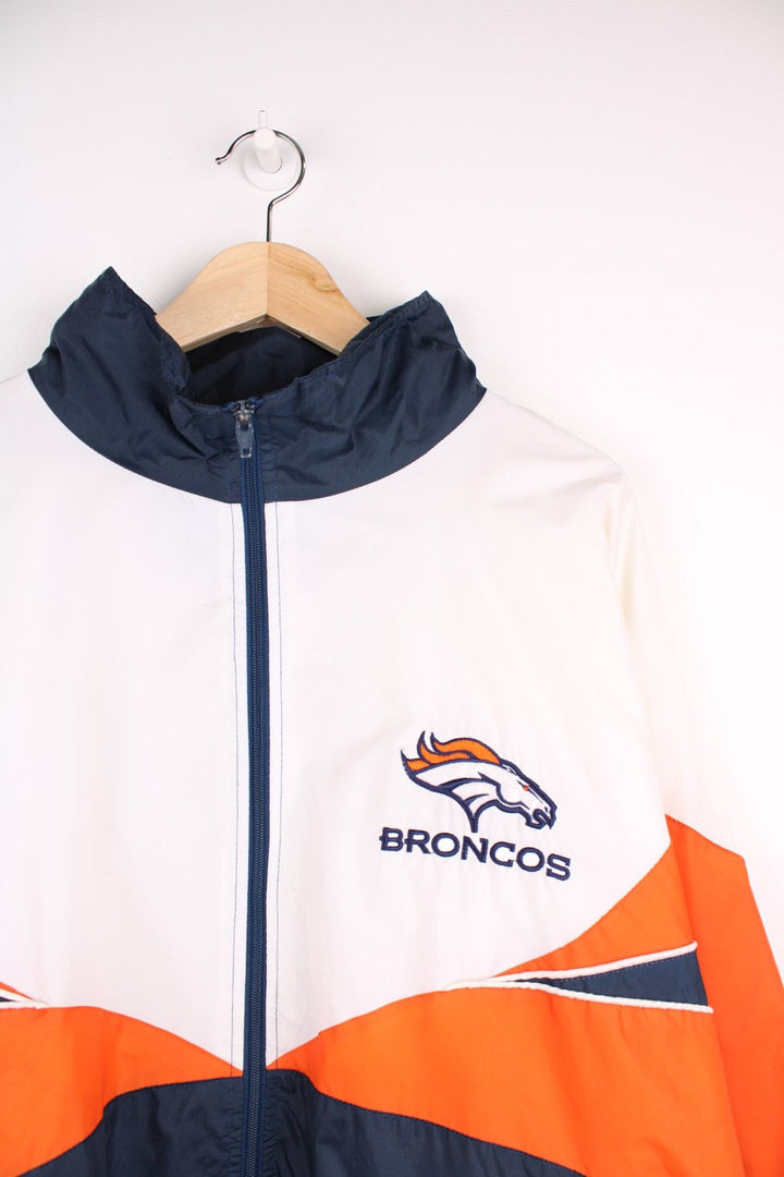 Broncos pro sport jacket in white, orange and navy. Zip closure with team logos embroidered on the front and back.