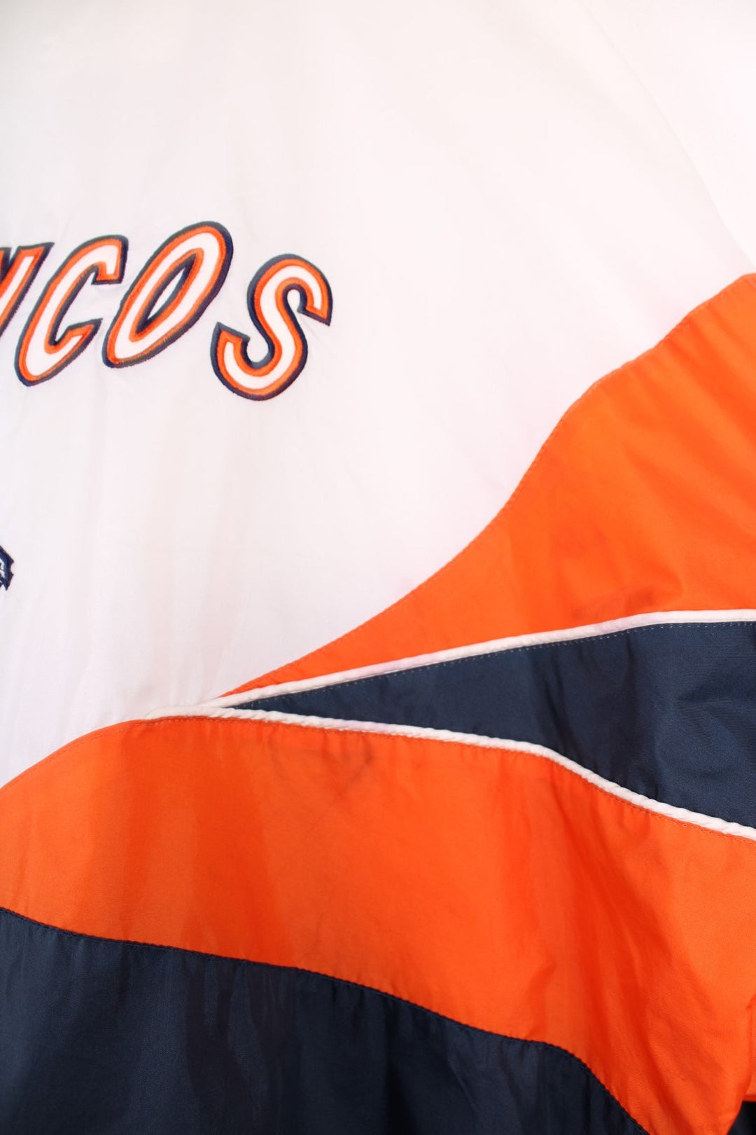 Broncos pro sport jacket in white, orange and navy. Zip closure with team logos embroidered on the front and back.