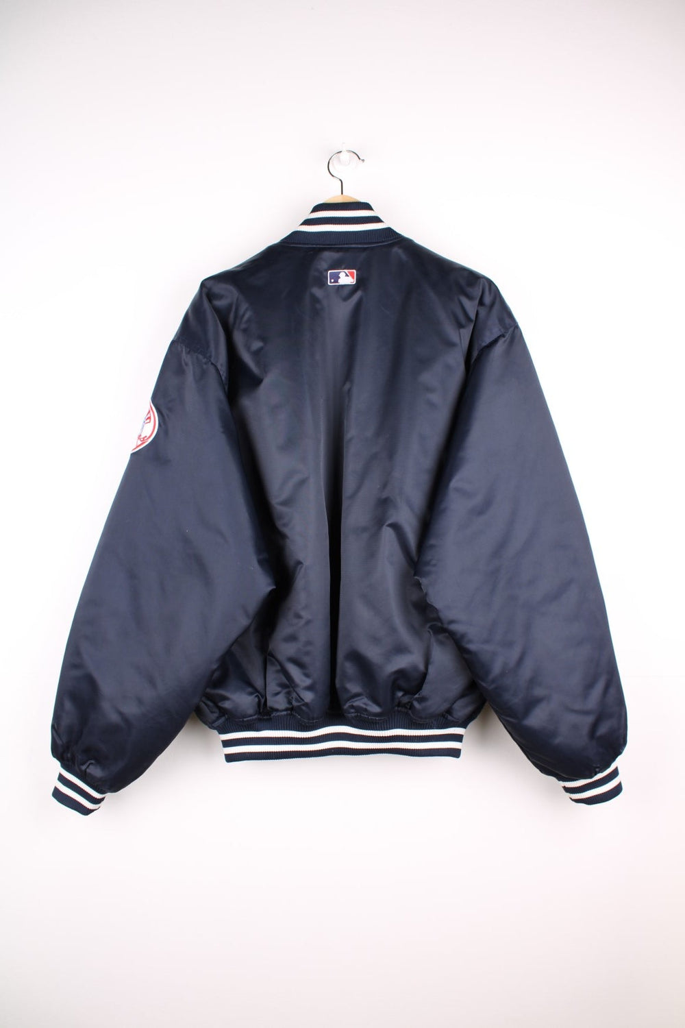 NY Yankees vintage pro sport bomber jacket in navy blue satin with white stripe detail. Snap fastener closure, with team logos embroidered on the front and sleeve.