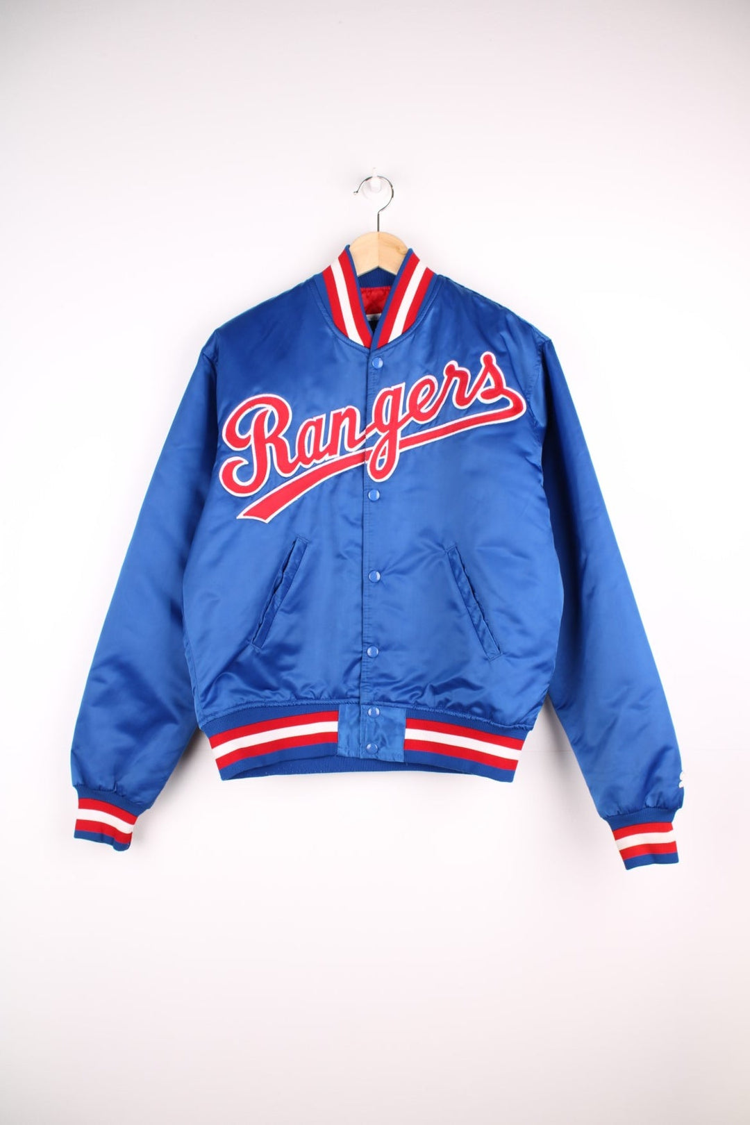 Texas Rangers pro sport jacket in a blue colourway with white and red stripe detail. Snap fastener closure with team logos embroidered on the front.