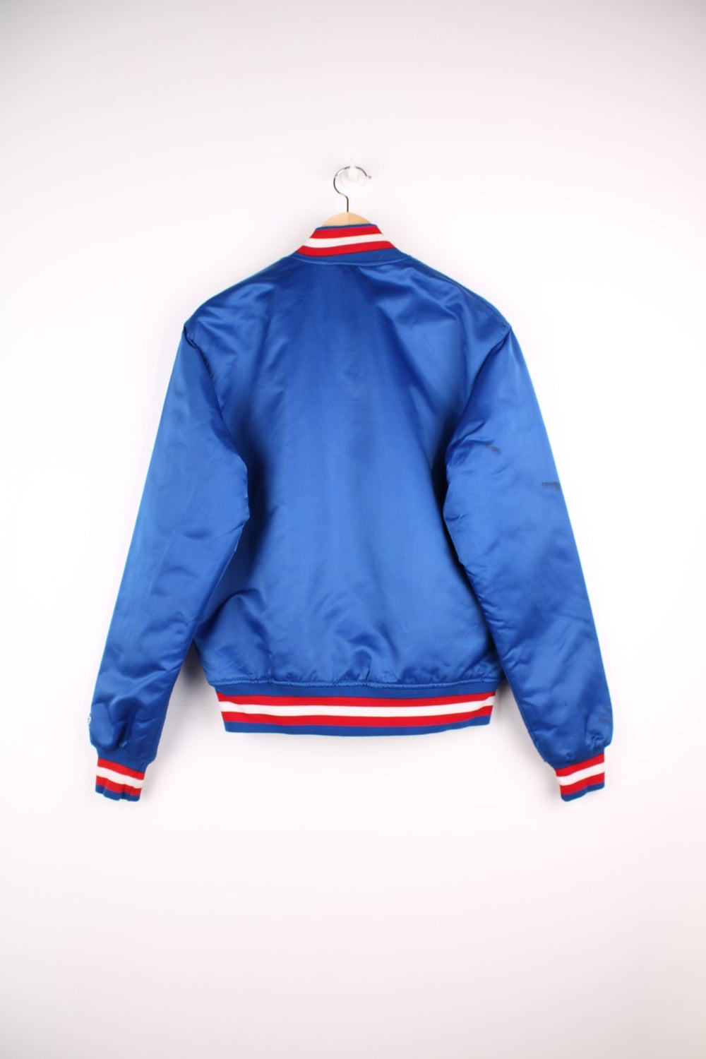 Texas Rangers pro sport jacket in a blue colourway with white and red stripe detail. Snap fastener closure with team logos embroidered on the front.