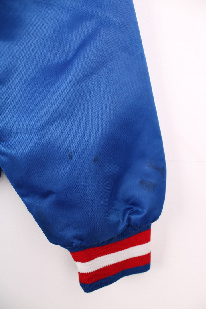 Texas Rangers pro sport jacket in a blue colourway with white and red stripe detail. Snap fastener closure with team logos embroidered on the front.